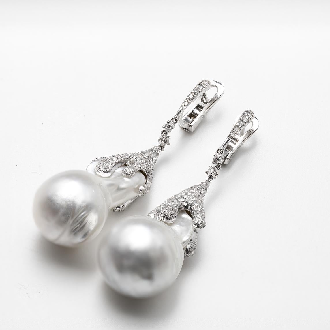 A pair of Baroque South Sea Pearls White with Silver Overtones 18 x 34.5 Milimiters respectively with High Luster set in 18 Karat White Gold with Round Brilliant Cut Diamonds G - H Color VVS Clatity of 4.15 Carat Total Weight. Posts at the back for