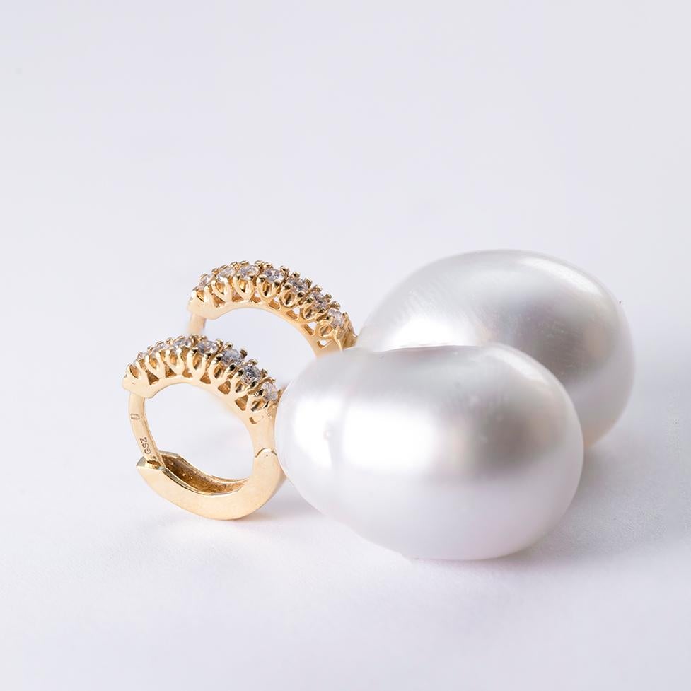 White Baroque South Sea Pearls 20 x 13.95mm and 20.3 x 13.90mm respectively of beautiful luster set in small Diamond hoops in 18 Karat Gold and 0.45 Carat Diamonds of H Color and VS Clarity. They are made for pierced ears.