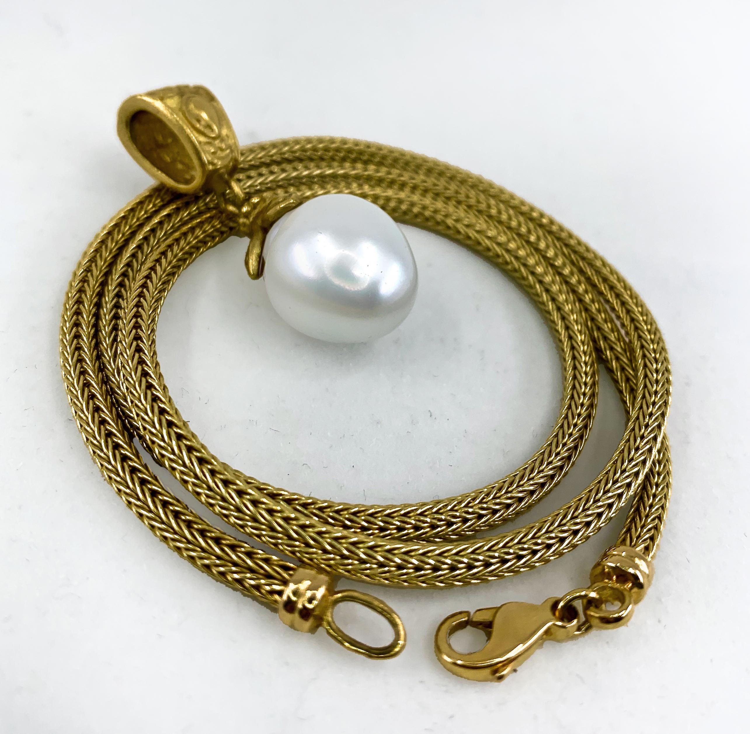This large (13.5mm), lustrous white South Sea pearl is set on a Byzantine-flavored 18 karat yellow gold pedant handmade in our shop by Eytan Brandes.  It is perfectly partnered with a thick 14 karat yellow gold wheat chain.  

The pearl is 13.5mm in