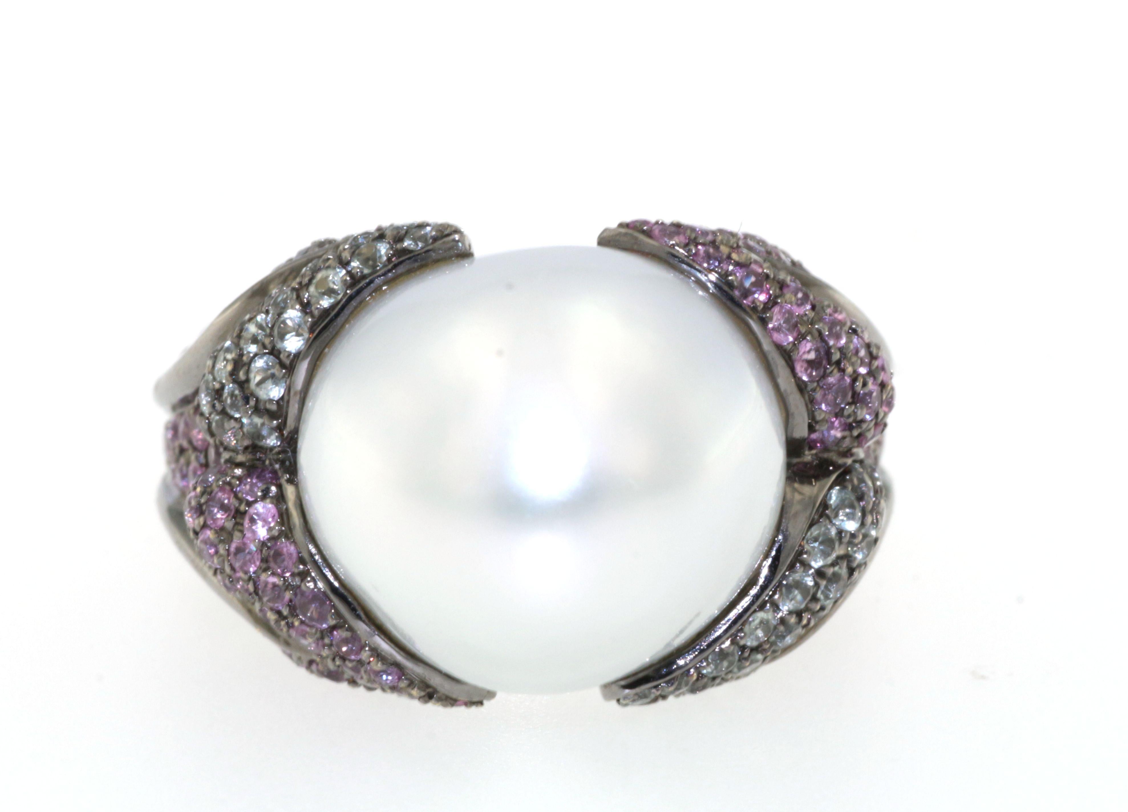 This pearl ring features a 13mm baroque south sea pearl assented with 1.08 carat of green sapphire and 1.18 carat of pink sapphire. The rhodium black gold offers a great contrast with the white baroque pearl, it's definitely a eye-catcher piece.
