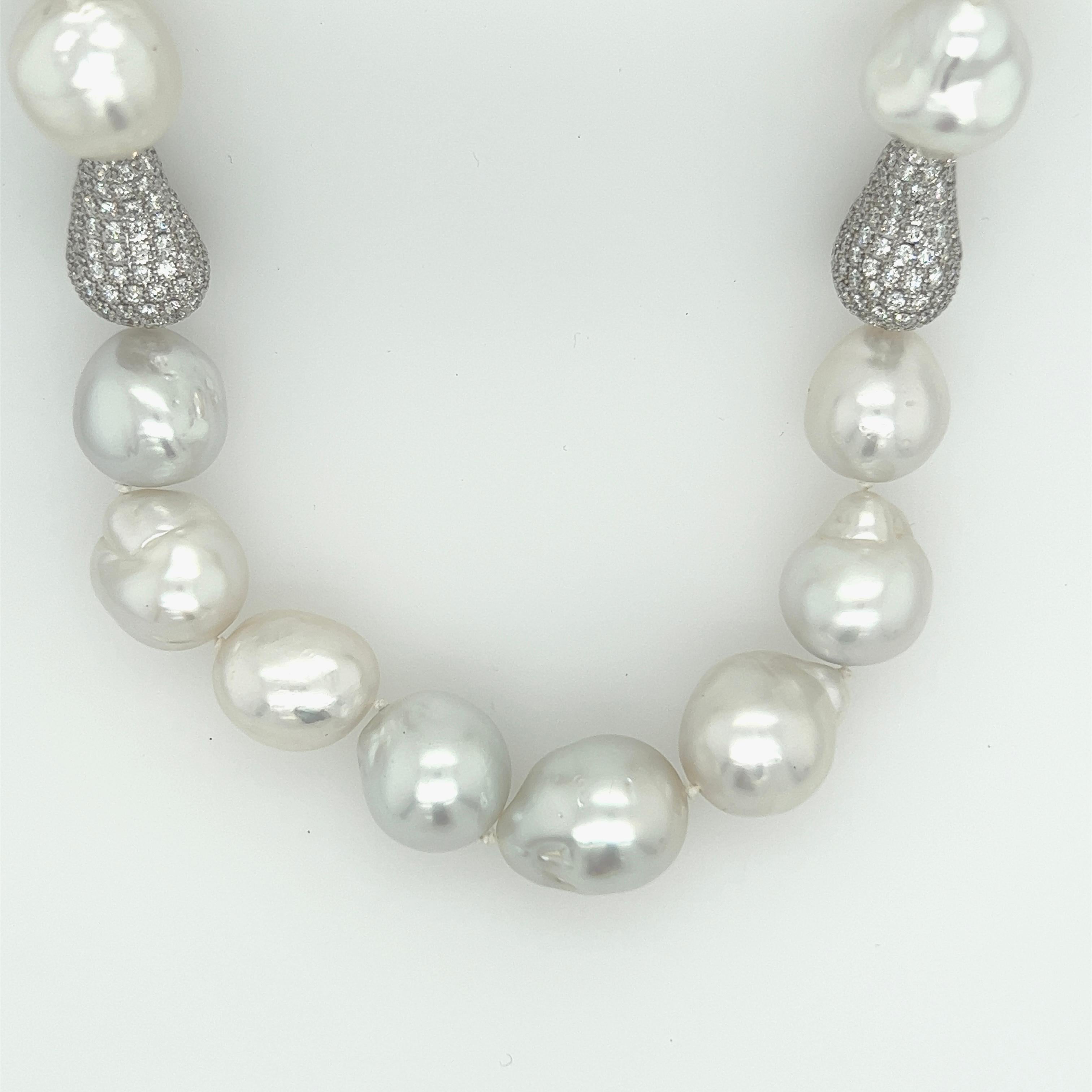 Magnificent cultured baroque south sea pearls with baroque pearl shape pavé diamond spacers. The 25 baroque pearls measure 15.50mm-12.00mm. The pearls are silvery white with excellent skins and orient. The 2 diamond spacers and clasp have 7.00carats