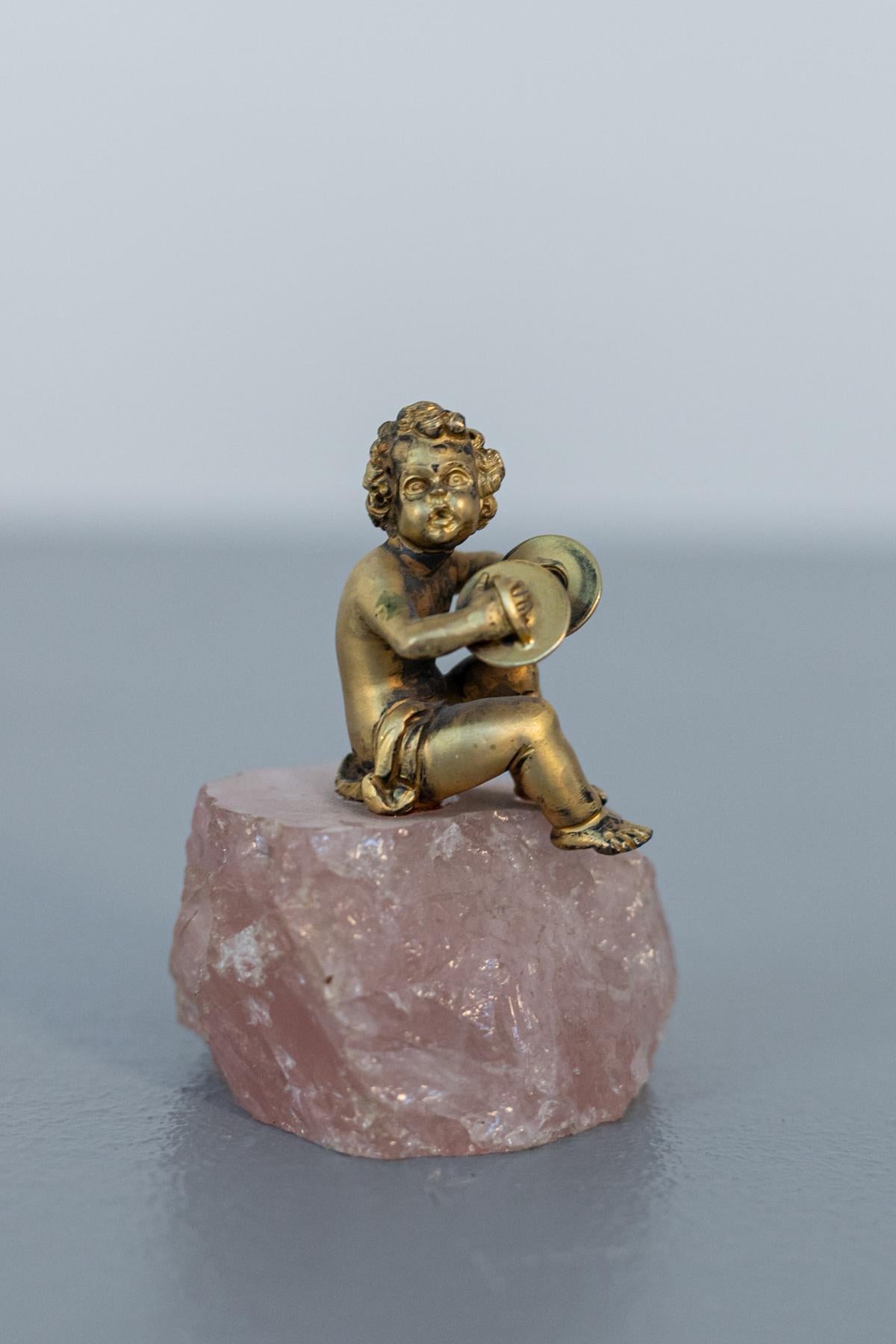 Gorgeous small statuette depicting a silver cherub from the Baroque period, late 1700s.
The statue is made entirely of gilded silver and depicts a musician cherub holding two plates. The putto is seated on a wonderfully elegant and charming rose