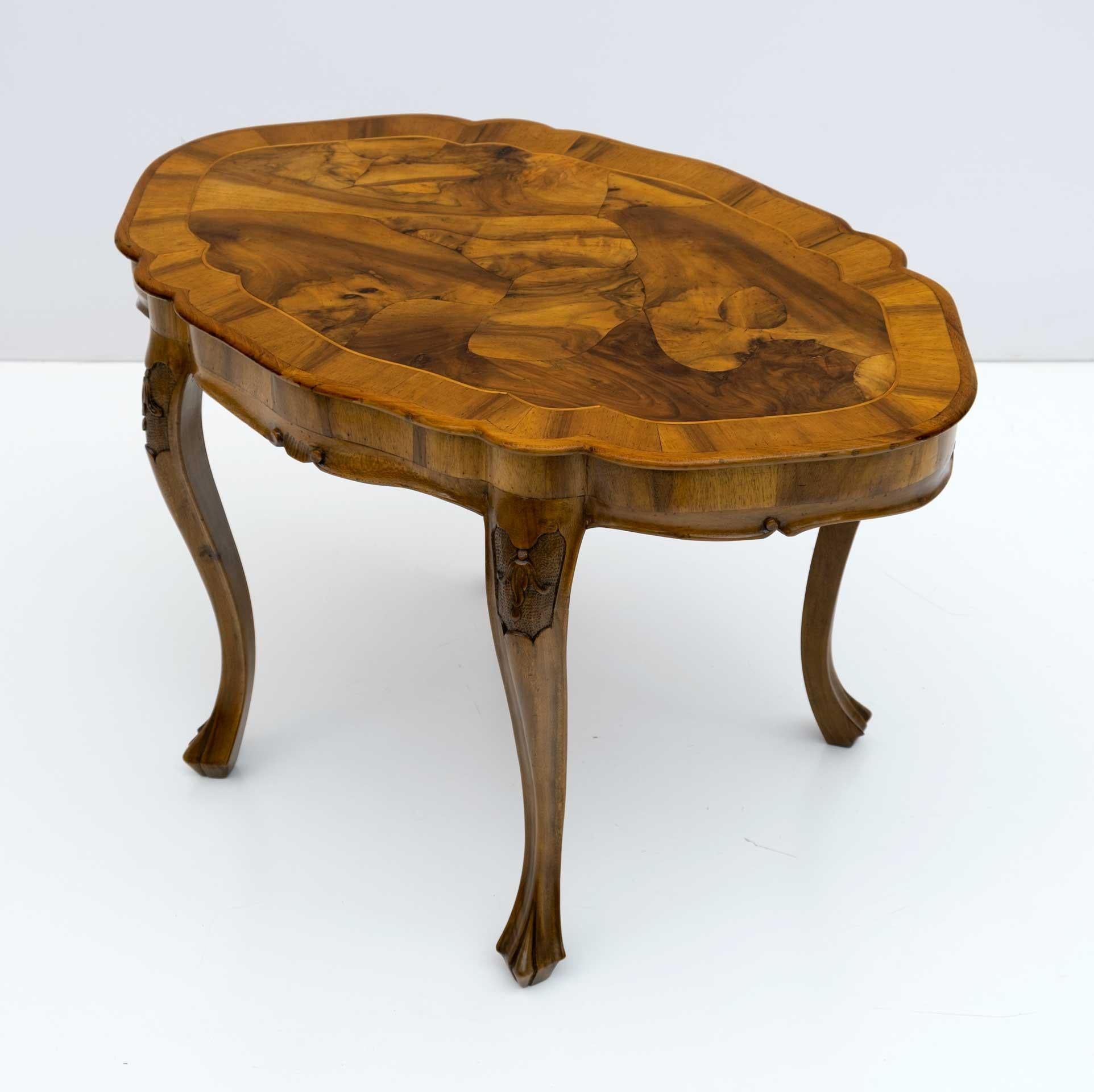 Rectangular coffee table in 18th century style, Venetian baroque. Built in the 20th century by Venetian master craftsmen. Shaped top doubled in walnut root. Carved shaped solid wood feet. The table is in the original patina. Restored with shellac.