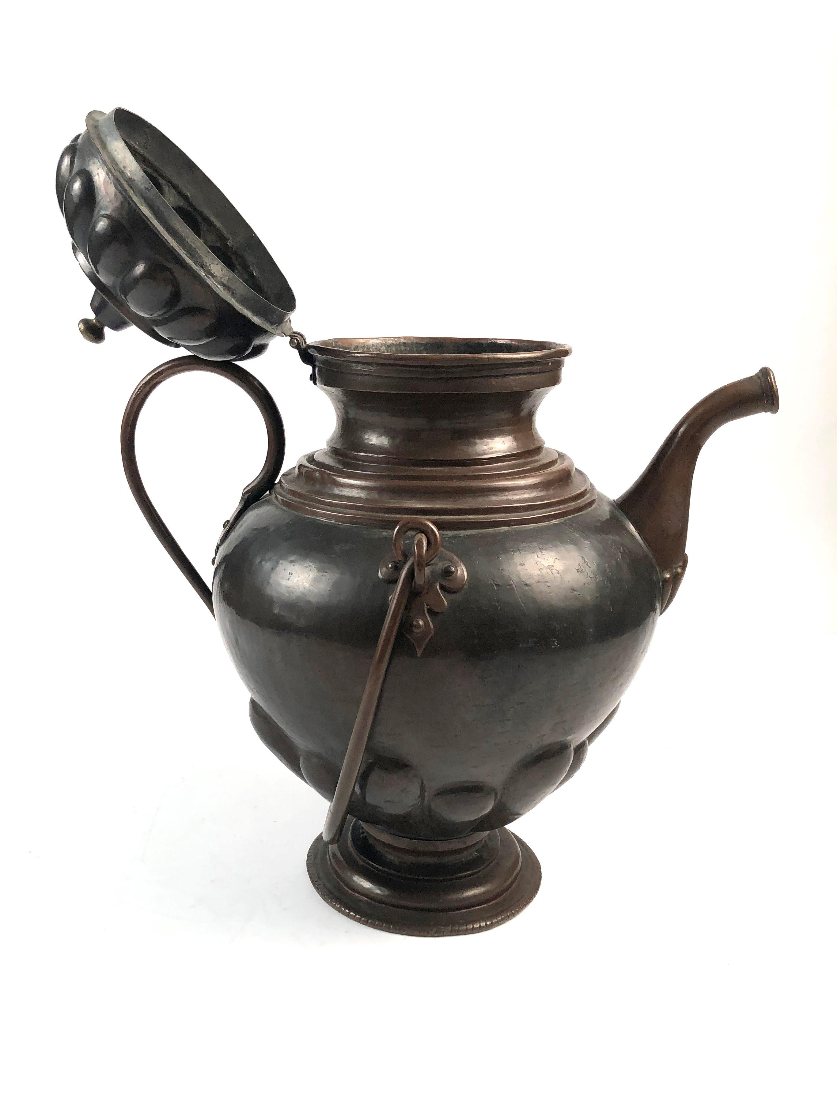 A handwrought beautifully detailed copper kettle with repousse gadrooned decoration on the lid and lower section, a fixed strap handle and swinging larger handle. Excellent form and patina.