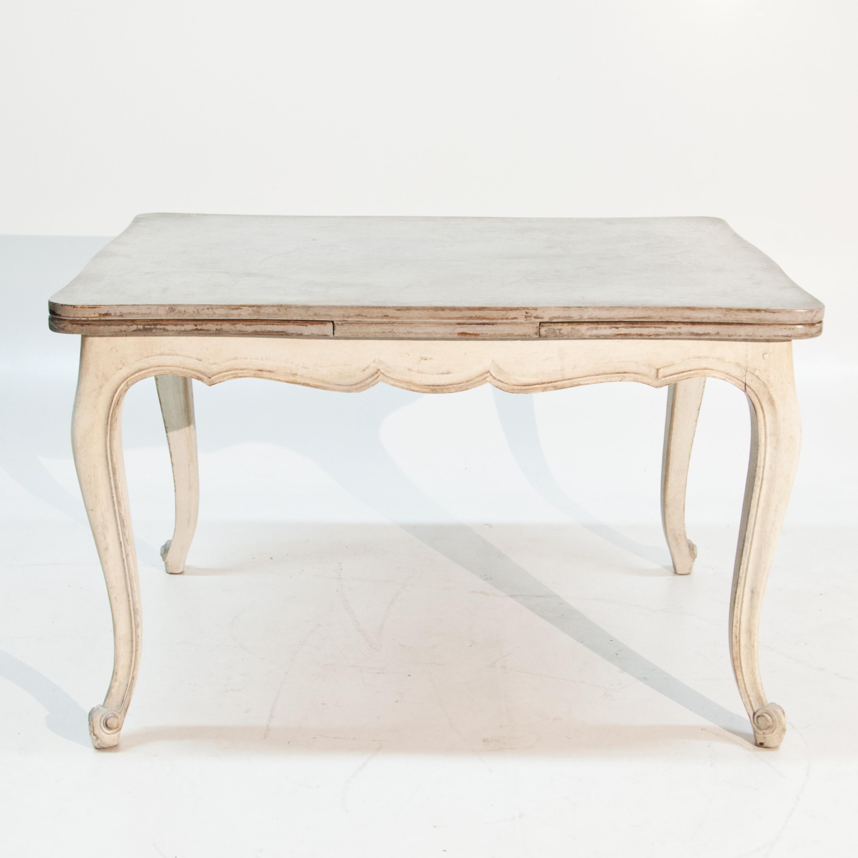 Baroque pull-out table on S-shaped legs with curved frame and tabletop. The table has been newly set in grey-beige and given an antique patina.