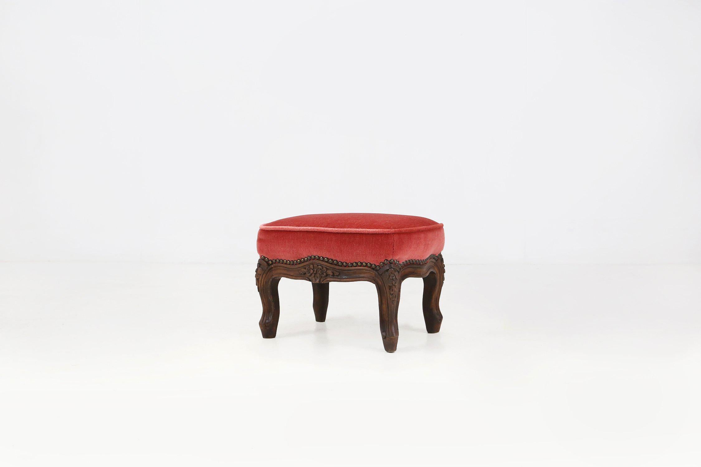 Carved Baroque style foot stool in carved wood with coral velvet upholstery For Sale