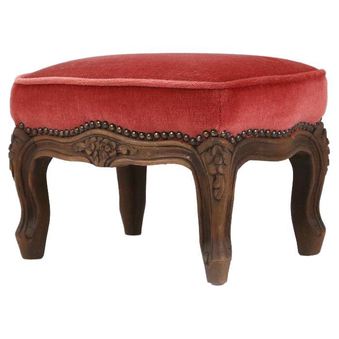 Baroque style foot stool in carved wood with coral velvet upholstery