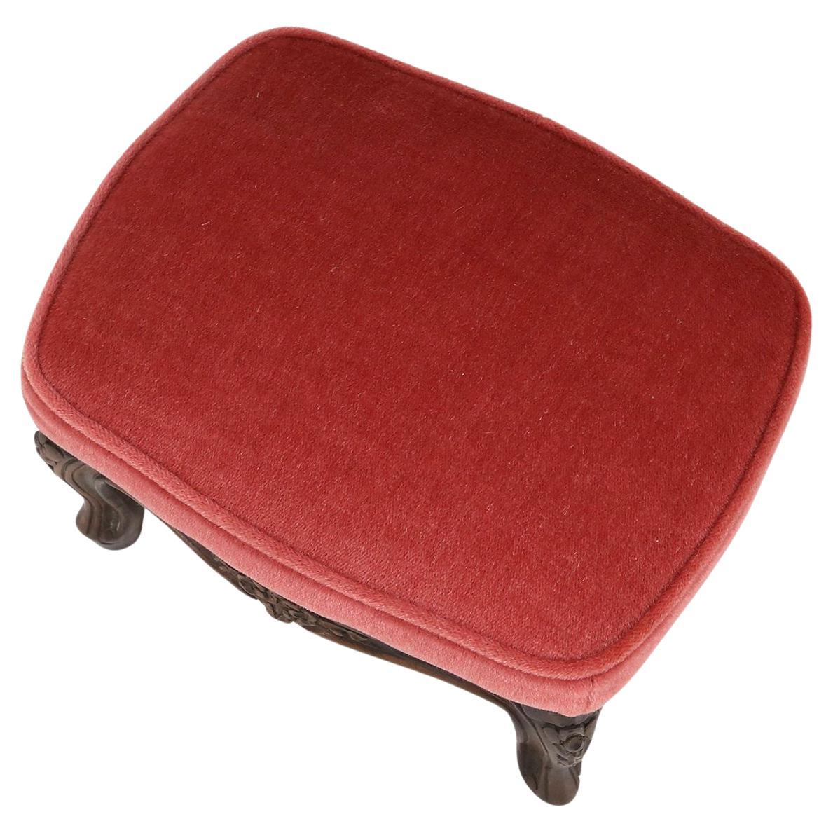 Baroque style foot stool in carved wood with coral velvet upholstery