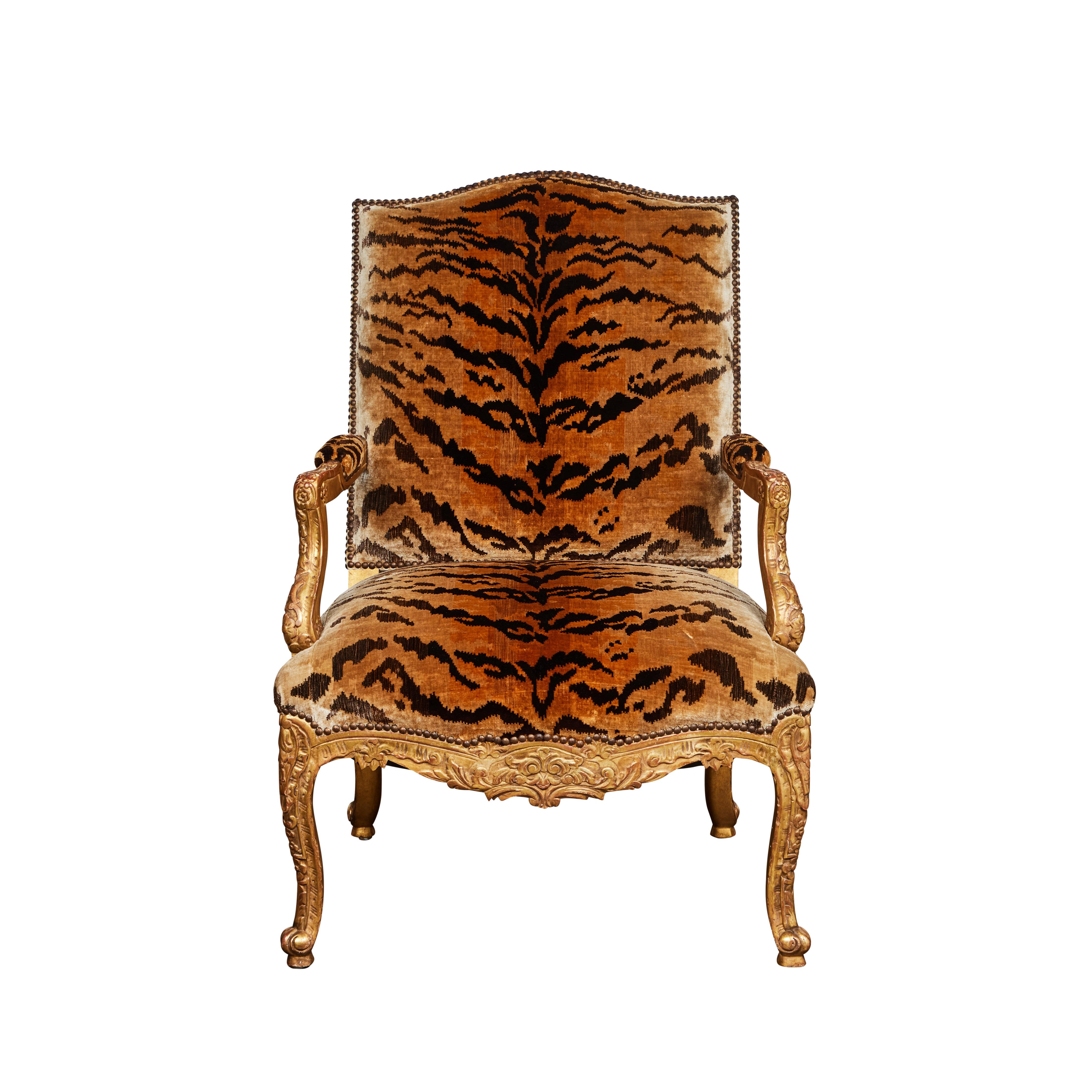 A French, hand carved, gessoed and gilded Baroque style armchair upholstered in Brunschwig and Fils silk tiger velvet