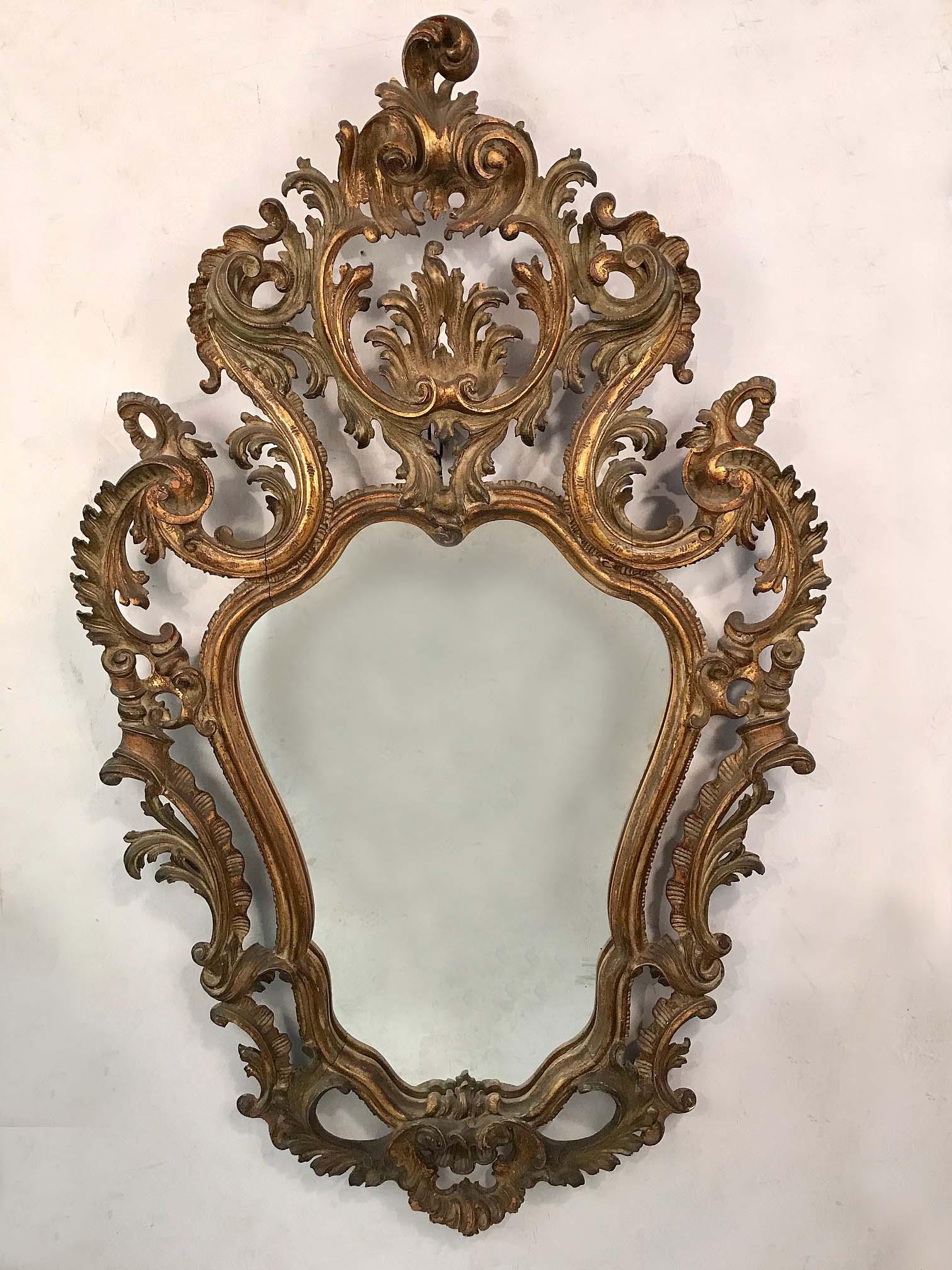 Questo specchio ha una cornice molto ben intagliata, frondosa, aperta e sagomata. Ha una leggerezza e un'esuberanza che fanno risaltare queste qualità nell'ambiente circostante.