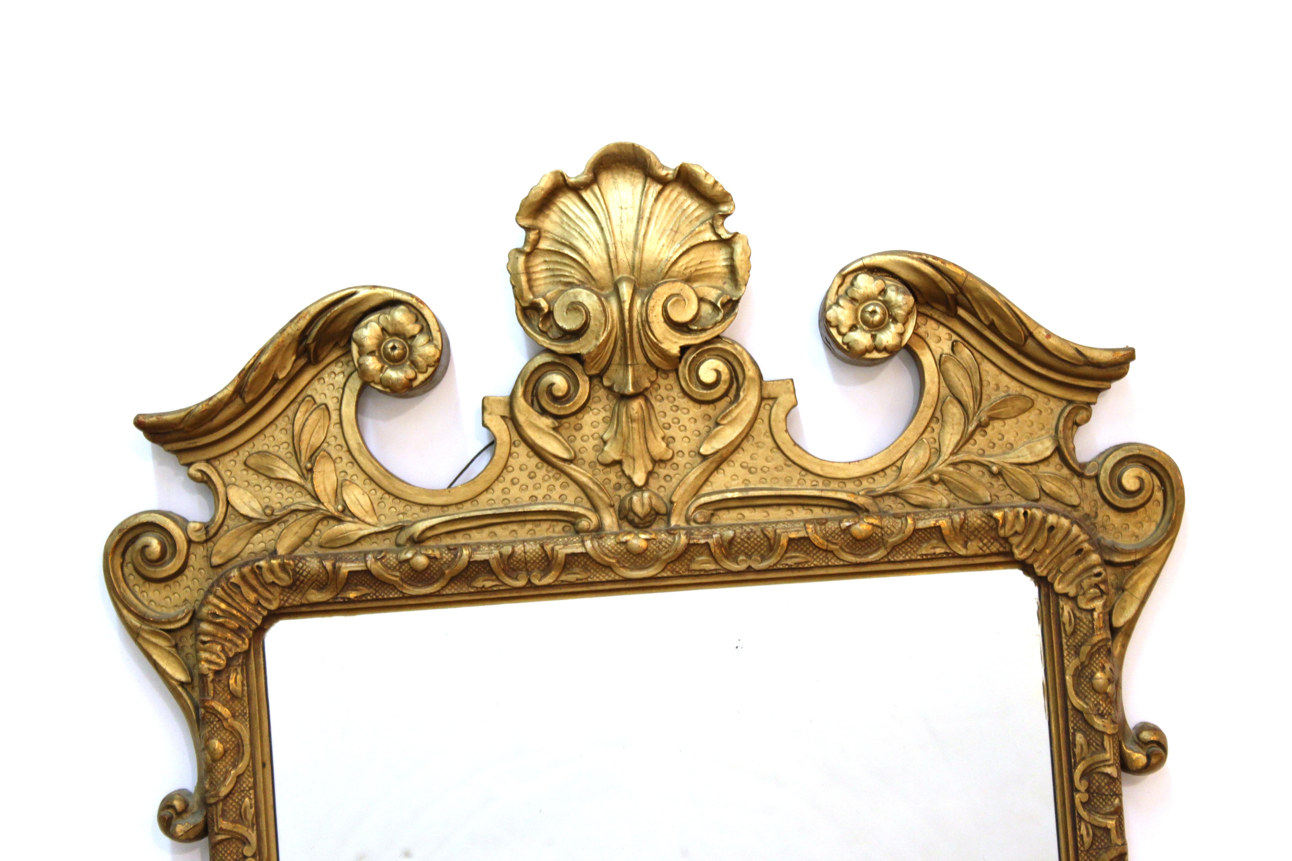 Baroque style carved giltwood wall mirror. The piece has a decorative border with volutes and shells.

Dealer: S138XX