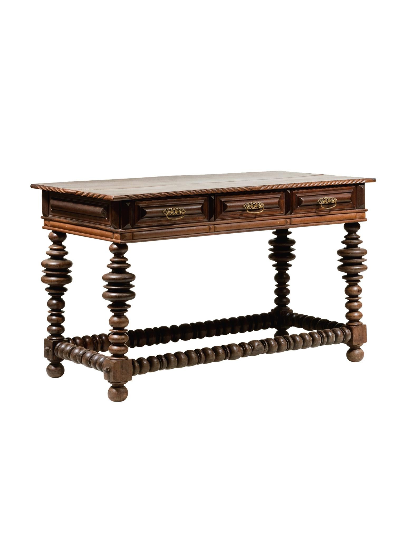 This Baroque-style Portuguese table was constructed in the 20th century. It is a marriage of antique parts. Overall the table is comprised of rosewood with a beautiful, warm tone. There are 3 drawer compartments with brass pulls. An outstanding