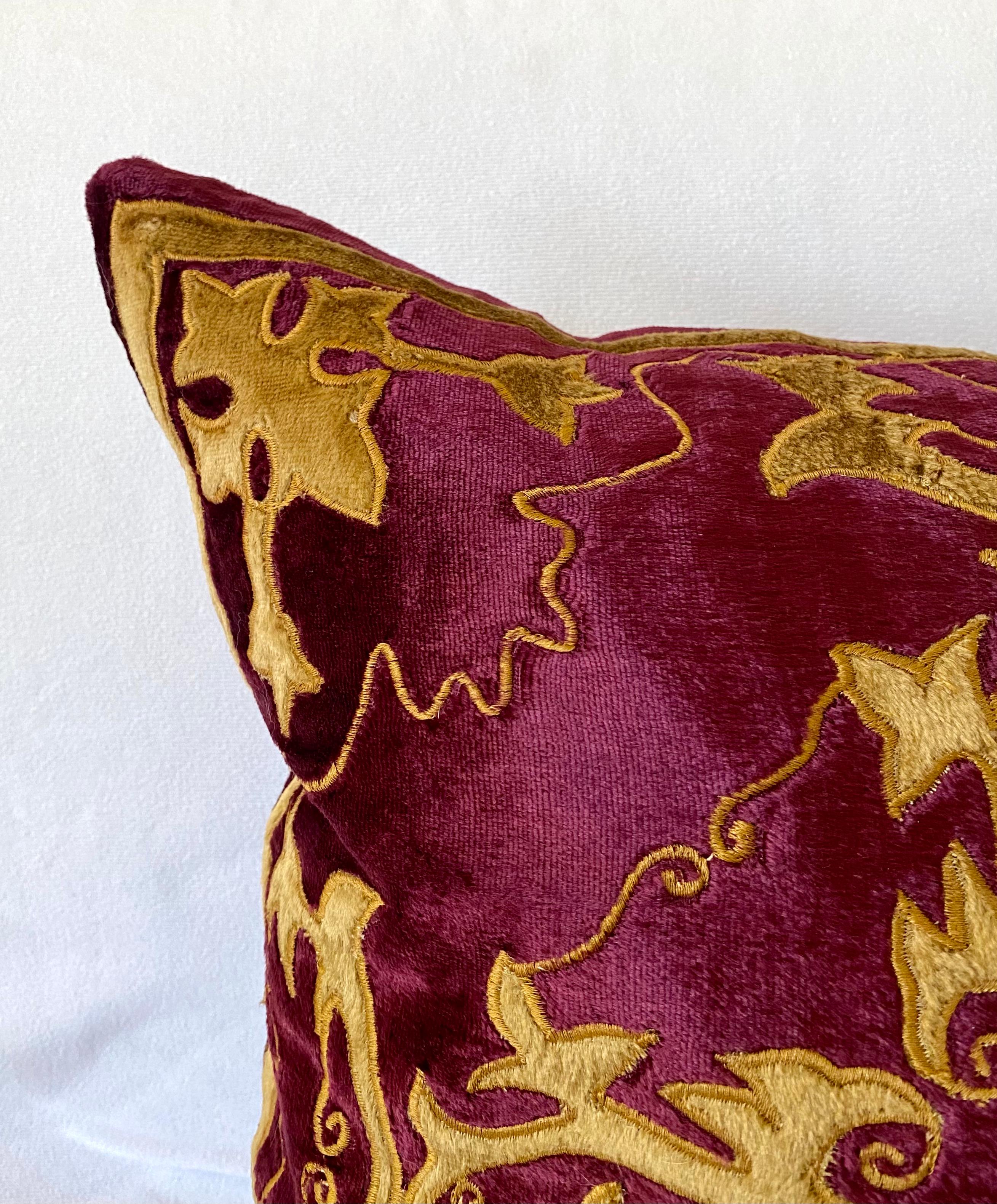 The claret color silky velvet pillow is elaborately decorated with baroque style applique work
in gold velvet outlined with gold embroidery. The pillow is filled with a mix of 50% down and
50% feathers. 

 