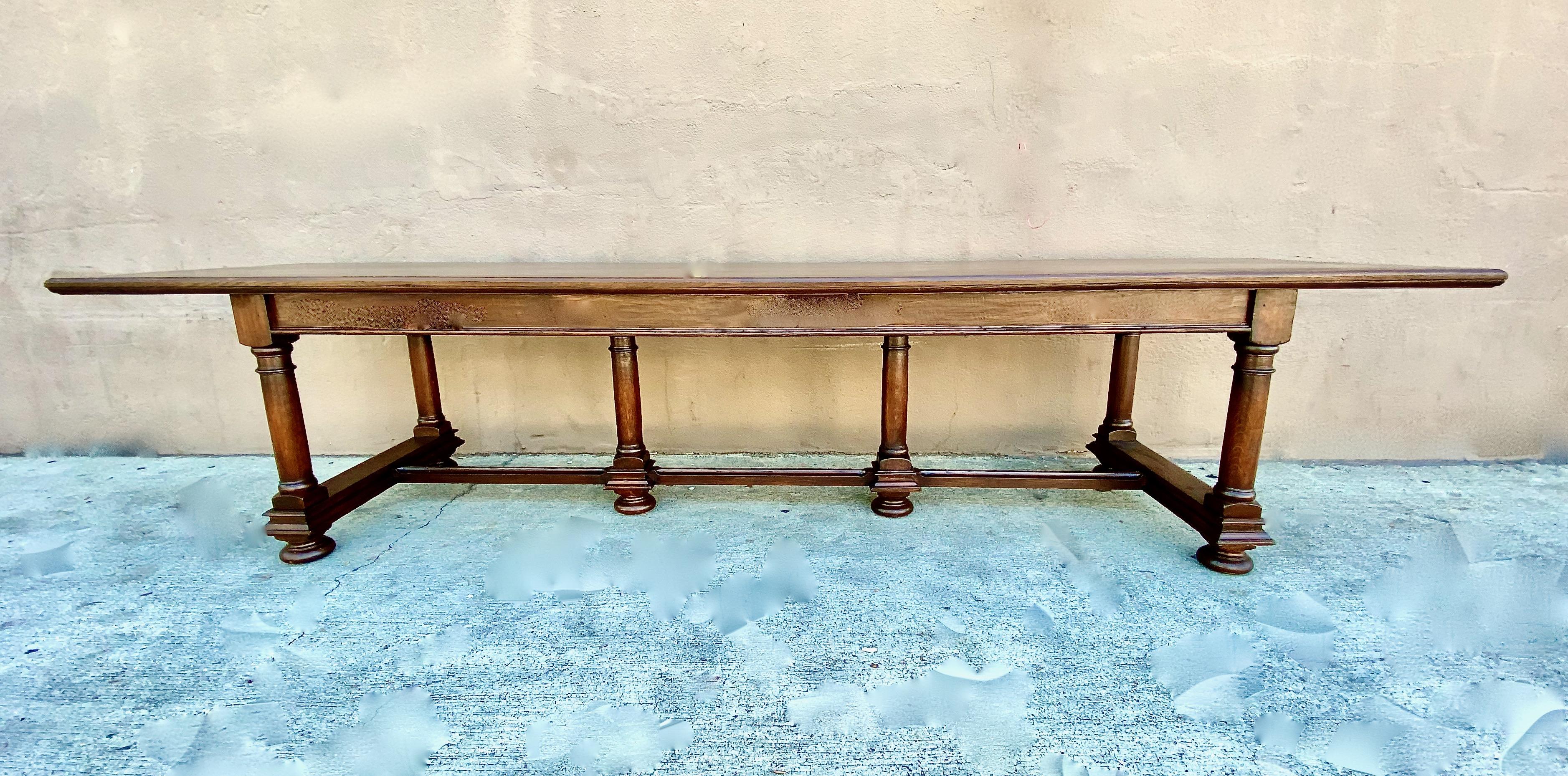 This is a long early to mid-20th century solid oak refectory table. The Italian Baroque style table is in very good to excellent condition with minor natural patina. Tables of this size and quality of construction are uncommon. The table measures: