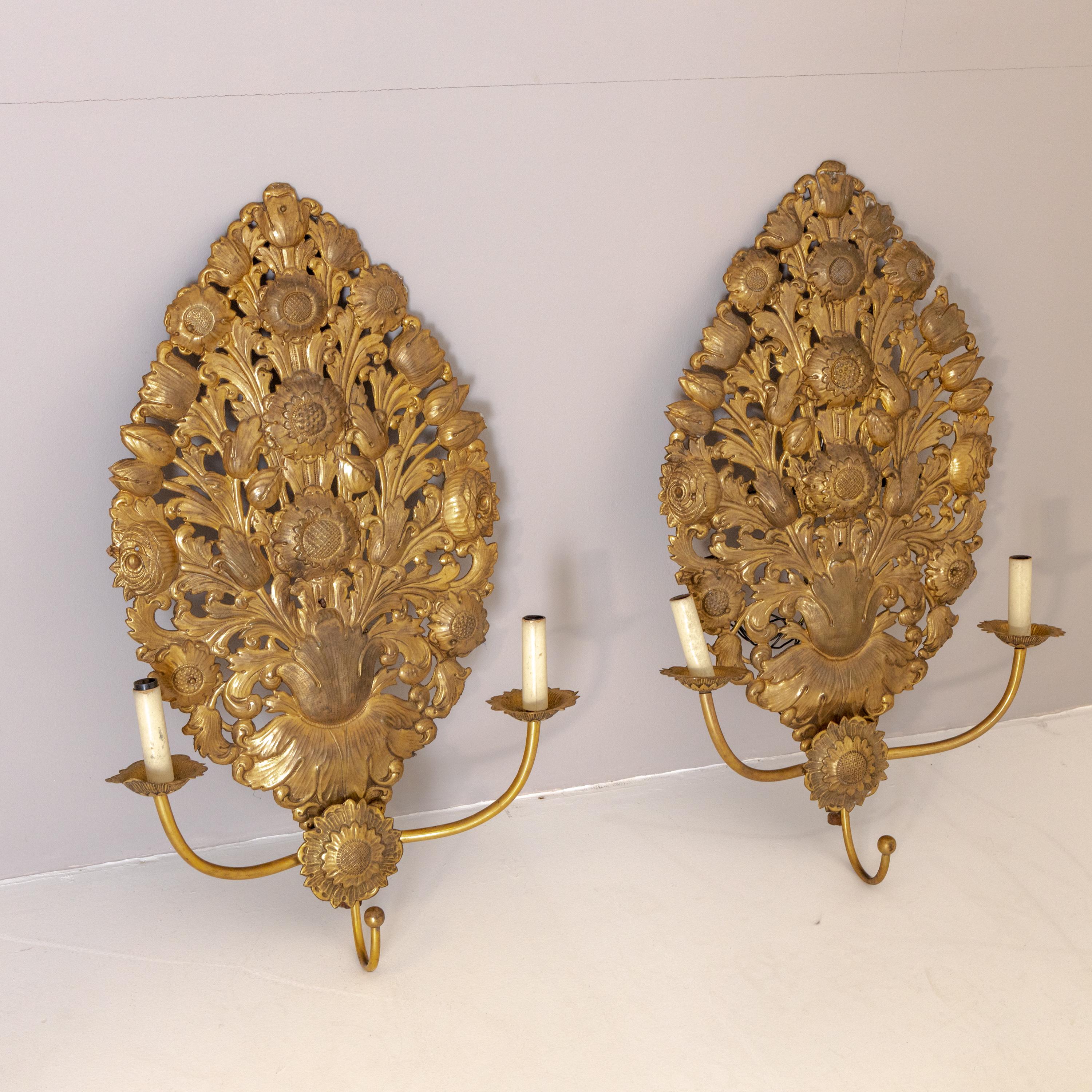 Two-armed wall appliques in baroque style made of chased brass in the shape of a large bouquet of flowers.