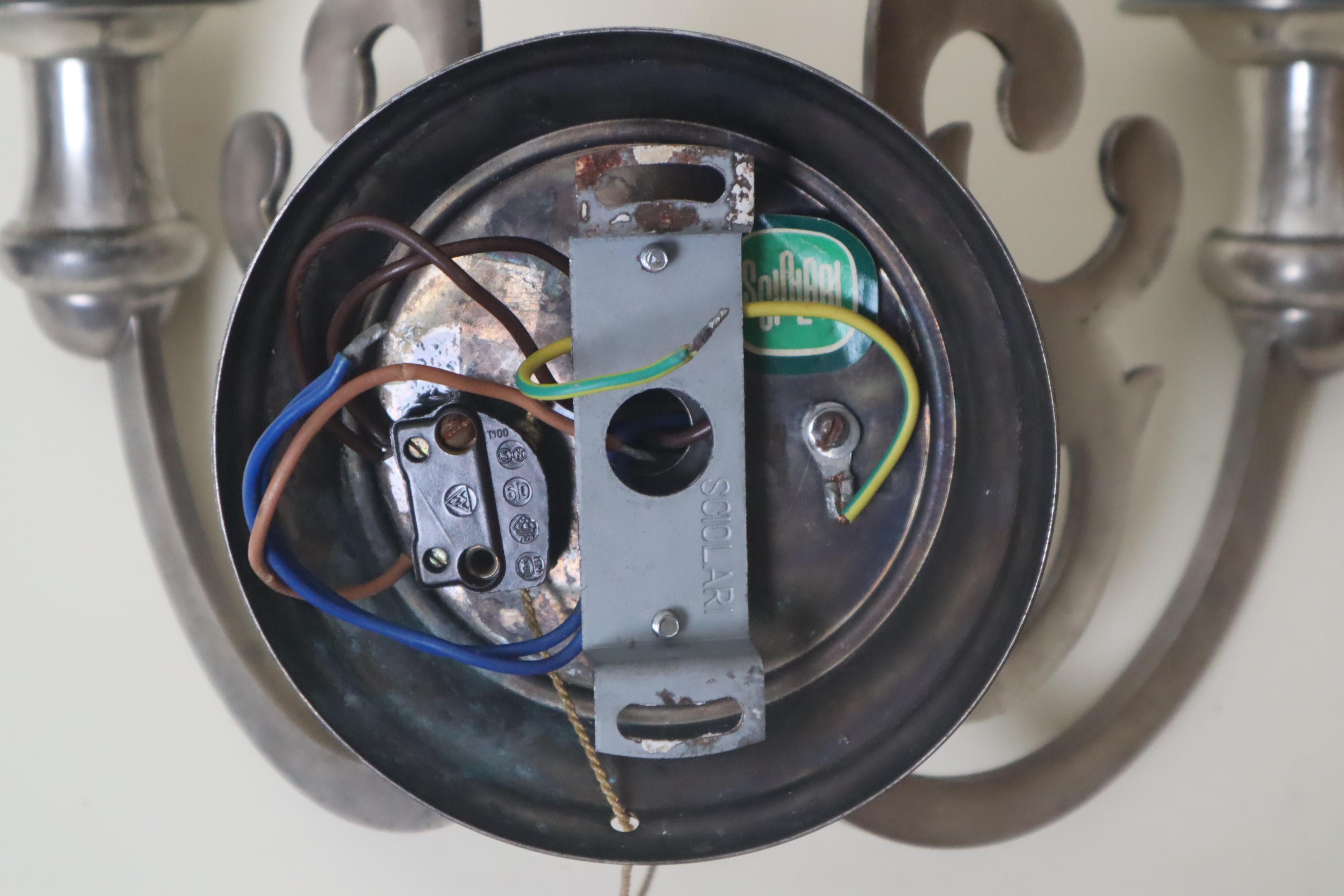 Este precioso aplique italiano del conocido fabricante italiano Sciolari es toda una rareza, con su diseño barroco. La lámpara tiene dos enchufes Edison E14 y, para nuestros amigos de EE.UU., hemos incluido reductores de rosca a E12 para facilitar
