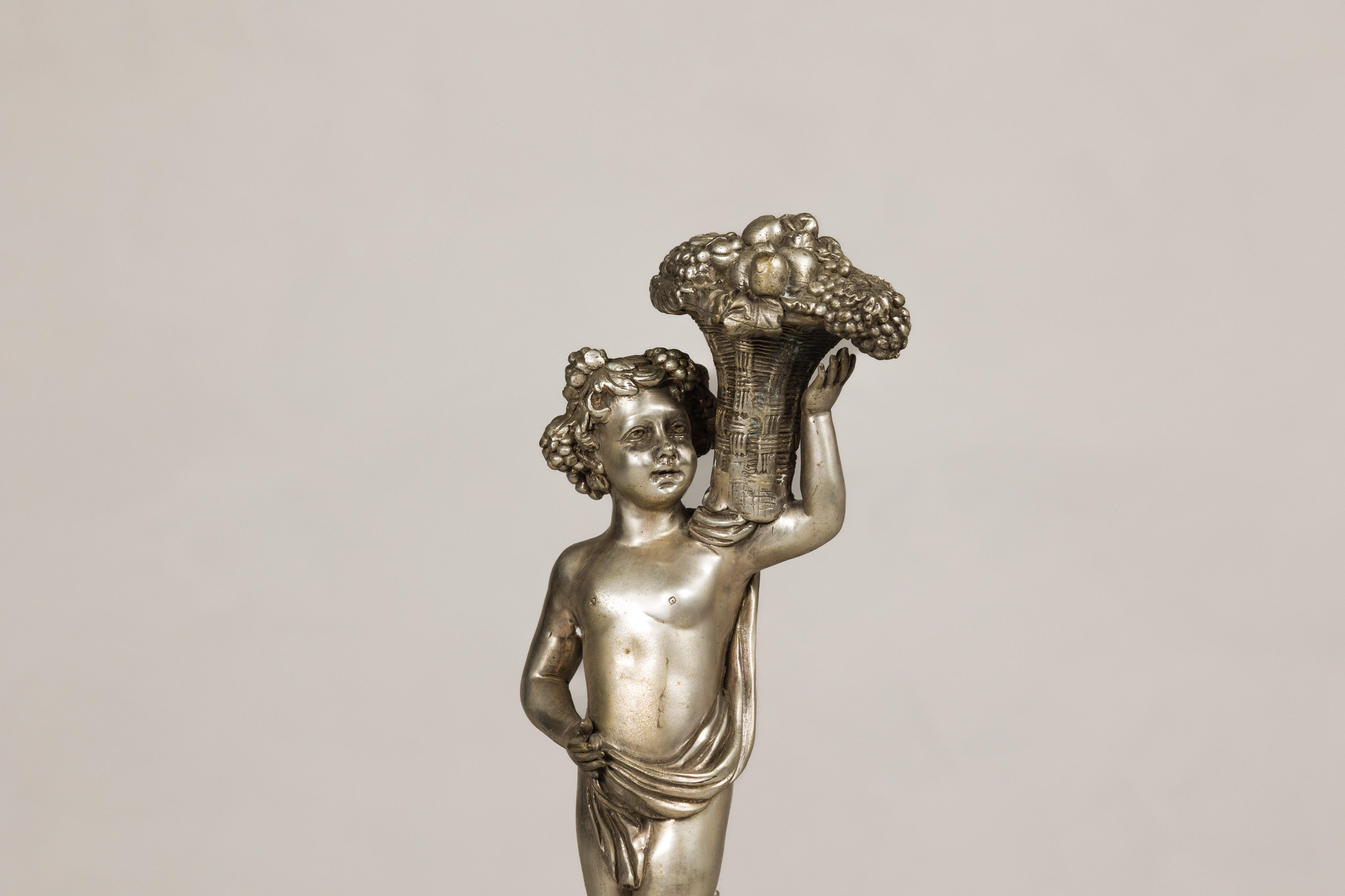 20ième siècle Statuette en bronze argenté de style baroque d'un putto transportant un panier de fruits en vente