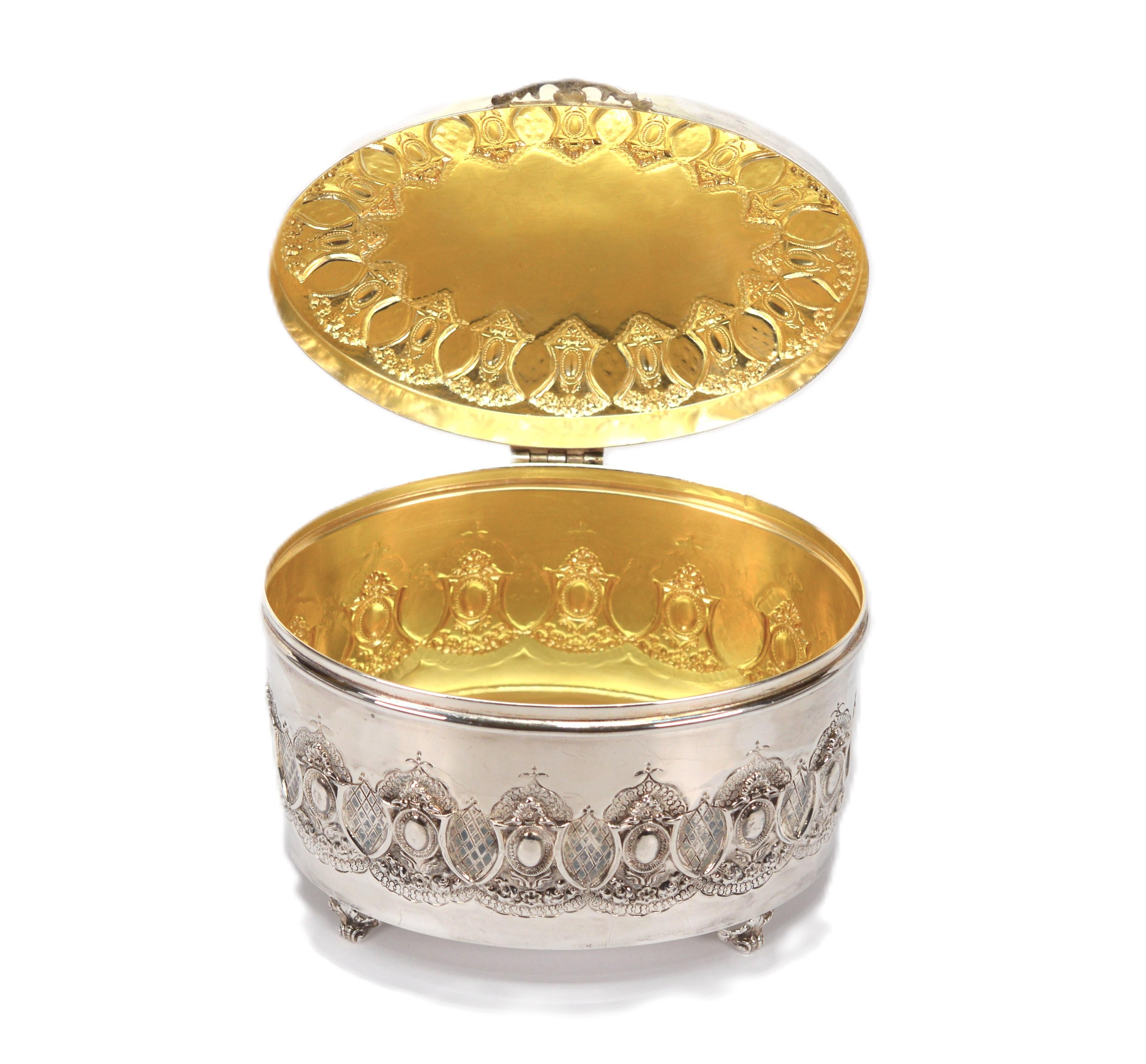 Beautiful handcrafted in sterling silver, one must appreciate the repousse craftsmanship displayed on this vanity jewelry box from the mid 20th century.  In Baroque style, intricately patterned designs adorn the circumference and the lid on this