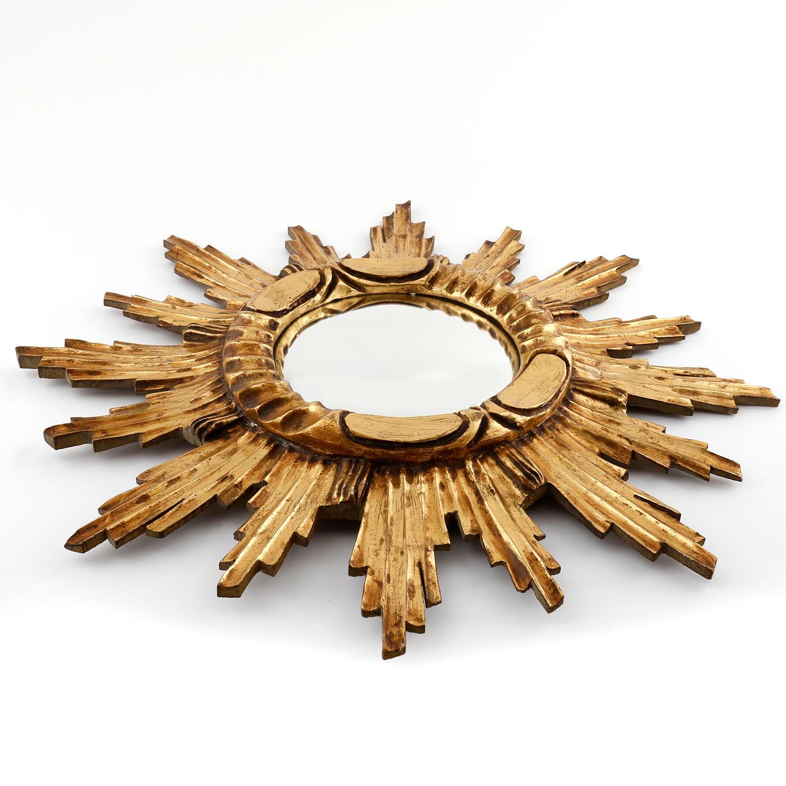 A beautiful sunburst mirror manufactured in Italy in early 20th century.
It is made of hand carved giltwood and a convex shaped polished metal (probably nickeled) metal mirror.
It has a lovely original vintage patina.