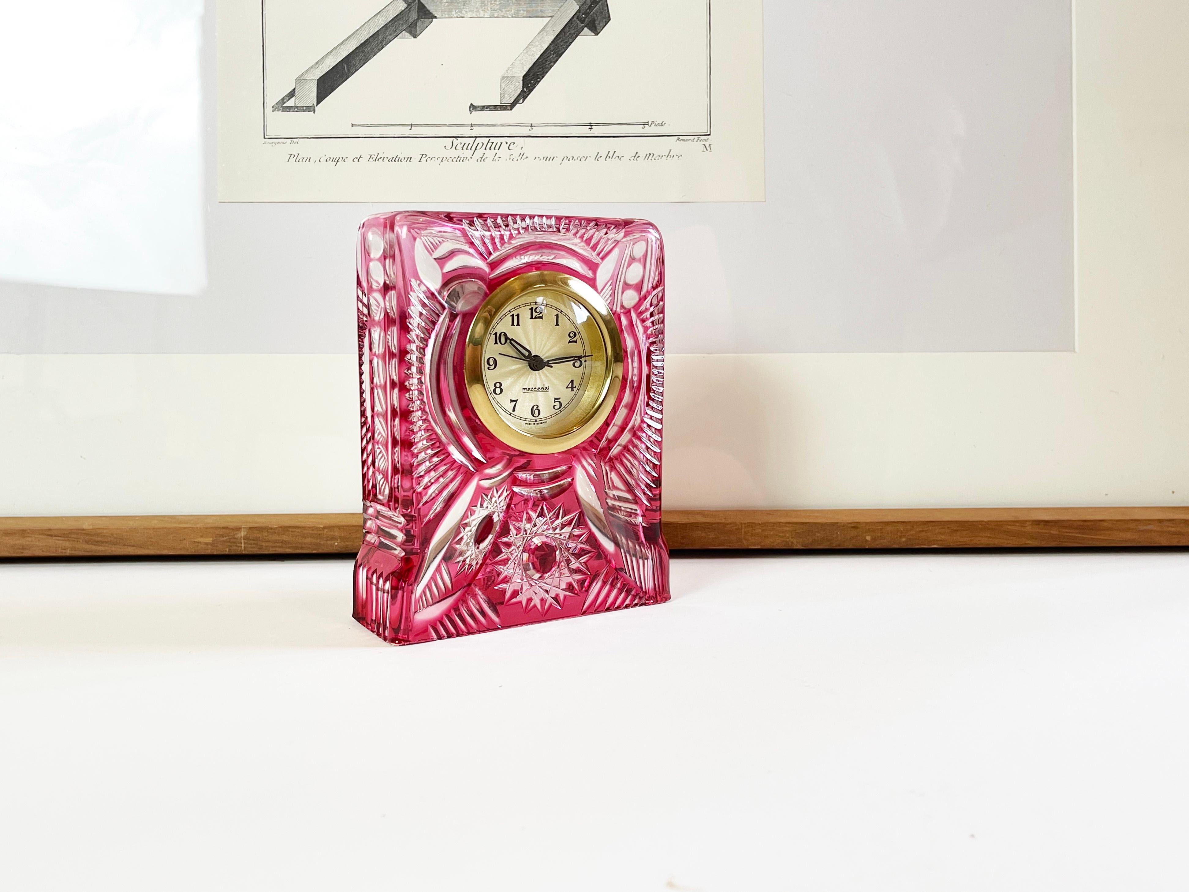 Elegante orologio da tavolo di lusso di Mercedes, Germania.
Realizzato intorno al 1965 in cristallo tagliato da rosa scuro a trasparente, con cassa in ottone e quadrante scintillante a forma di stella.
Il vetro tagliato divenne particolarmente di