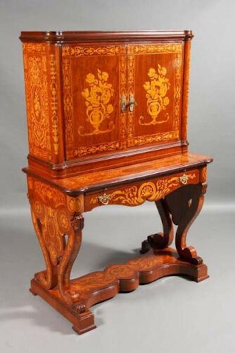 With rich marquetry in this version, it is very rare to find such a similar piece of furniture. The cupboard stands on paw feet, high-quality maceteria inlays on all sides, i.e. inlays laid on top of one another and not a completely carved inlay.