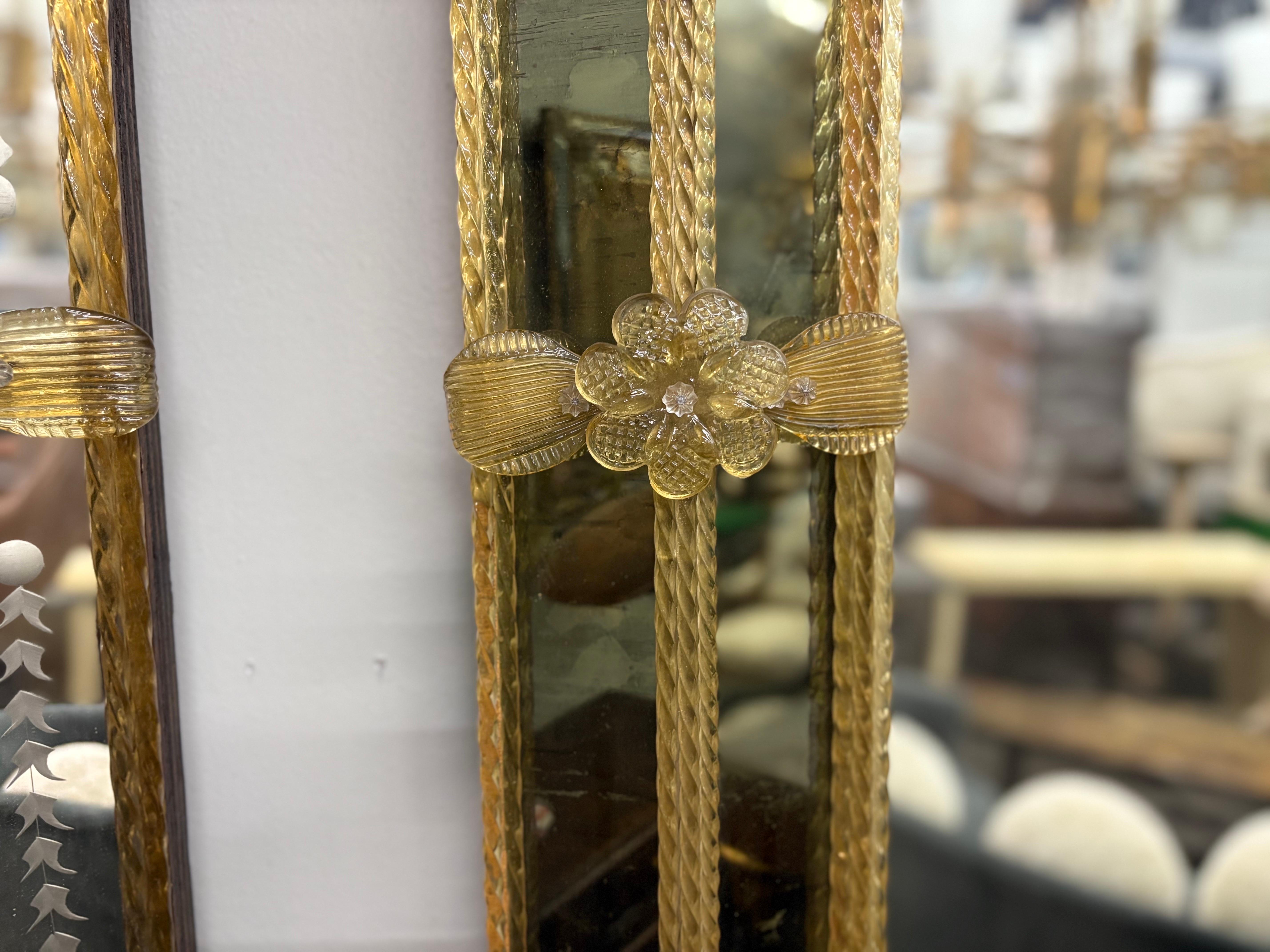 Miroir vénitien de style baroque.
Ce miroir vénitien rectangulaire de style baroque est composé d'un double périmètre de miroir sombre entourant un panneau central de miroir rehaussé de tiges, de fleurs et de feuilles en verre de Murano soufflé à la