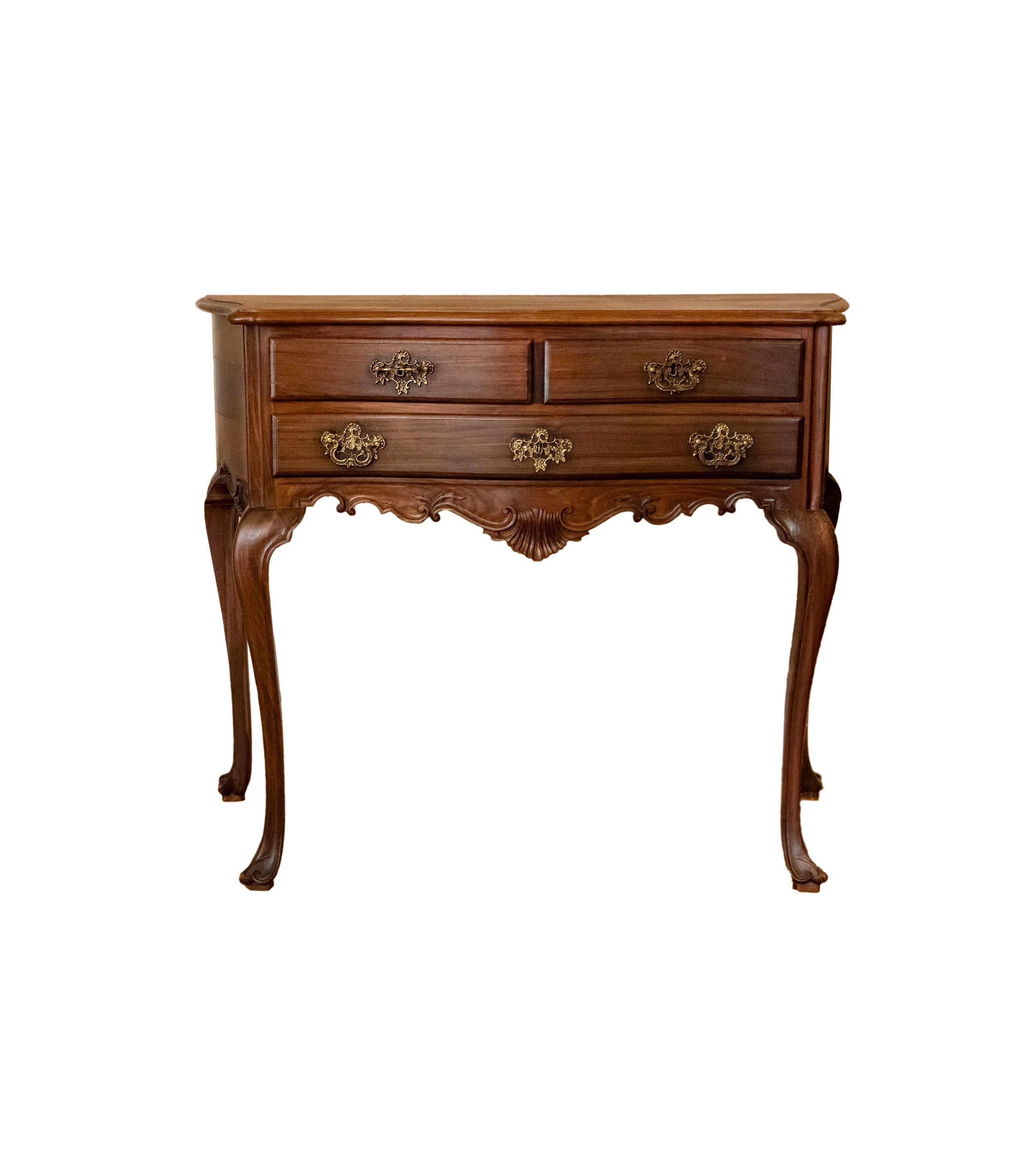 A Portuguese baroque style table commode with two drawers, vegetative marquetry skirt and bombée legs, three drawer and gilded hardware