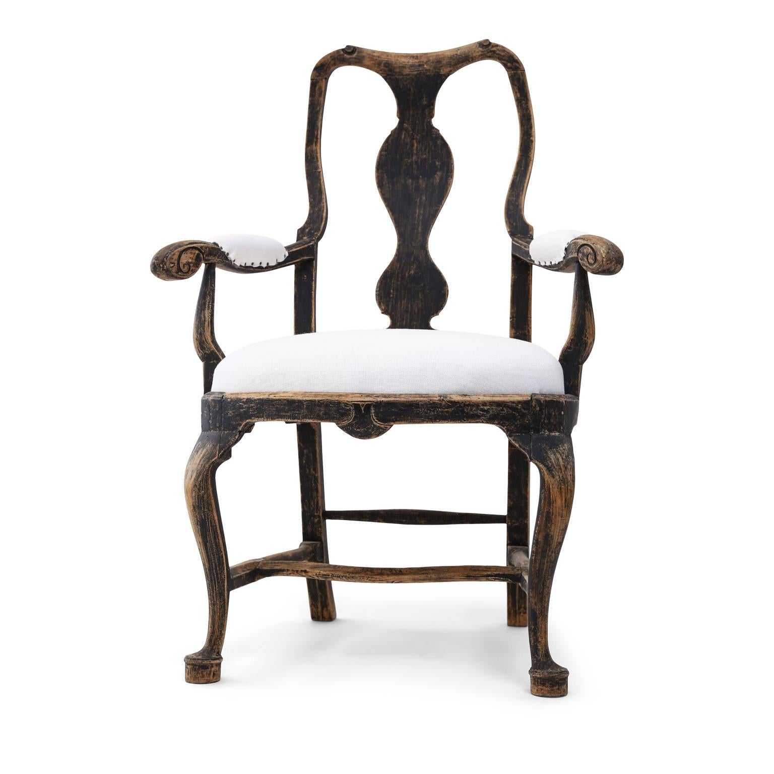 Baroque Swedish armchair dating to the early to mid-18th century (circa 1730-1750). Hand carved in the Classic late baroque style with rounded and shaped-splat back, crooked (cabriole) legs and pad feet. Some losses to its old painted finish and