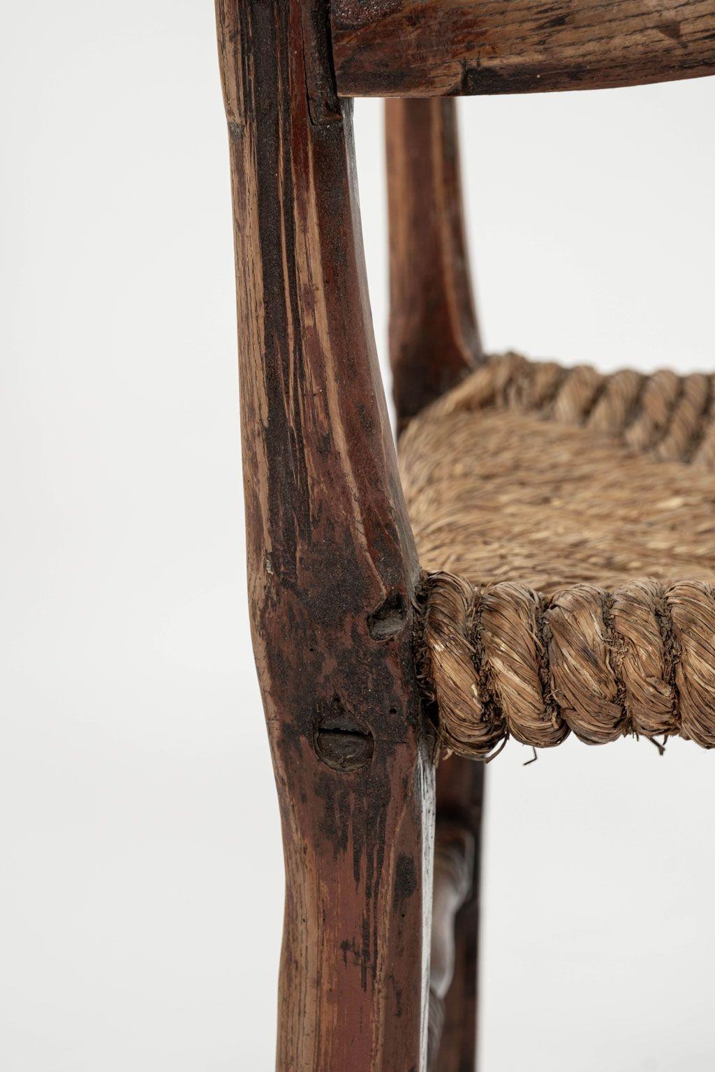 Baroque Swedish armchair hand-carved from beechwood and ash (circa 1670-1699), with traces of early ruddy-color paint. Well-worn prominent, almost-serpentine shaped, claw arms, original rope seat and turned upright supports connected by original