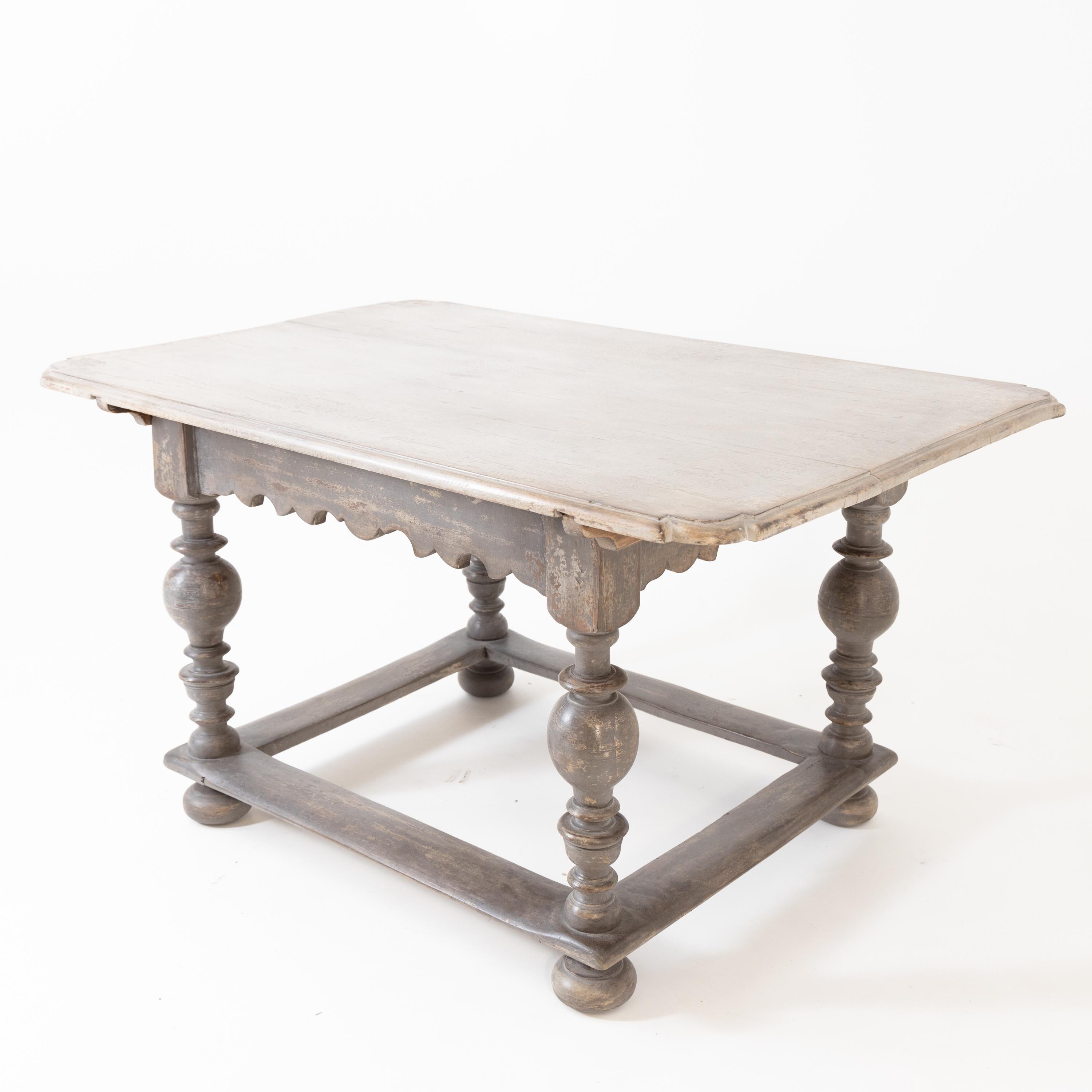 Baroque table on baluster legs with curved frame and circumferential bracing. The gray frame is new and has been decoratively rubbed through.