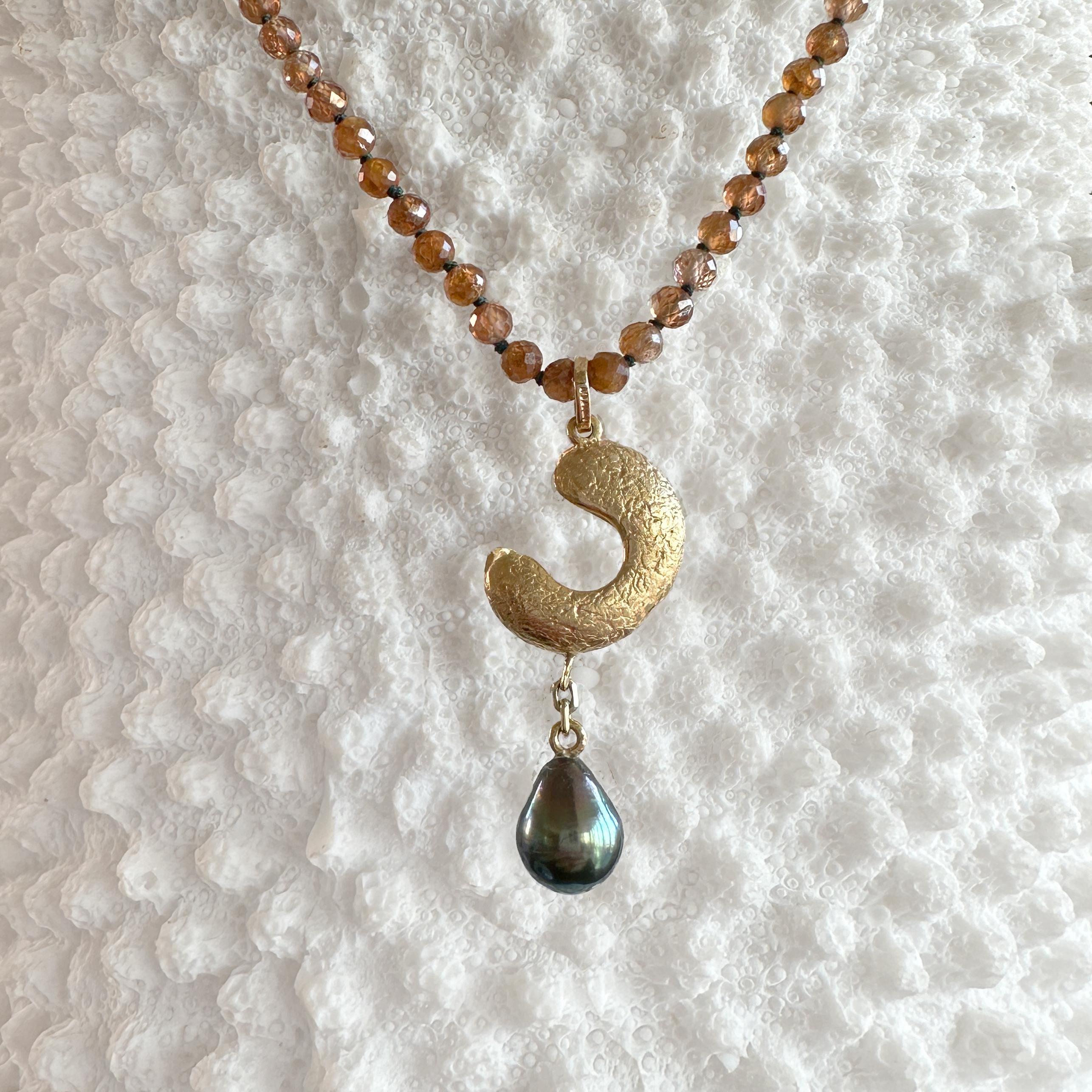 This gorgeous, one-of-a-kind 18 karat seed pod pendant by Eytan Brandes is cast from an actual seed pod.  For the drop, he chose a lustrous drop-shaped Tahitian pearl with stunning color -- black with strong green overtones.  

The bale is a