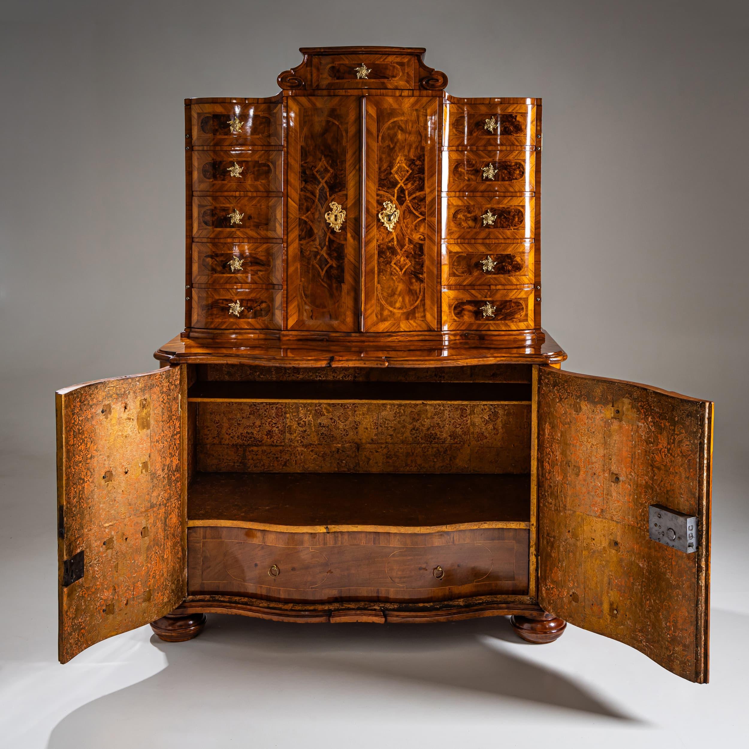 Raro mobile barocco con design trompe-l'œil: la sezione inferiore a due ante e la sezione superiore a due ante sono visivamente concepite per assomigliare a un comodino. La parte superiore è coronata da un piccolo cassetto fiancheggiato da