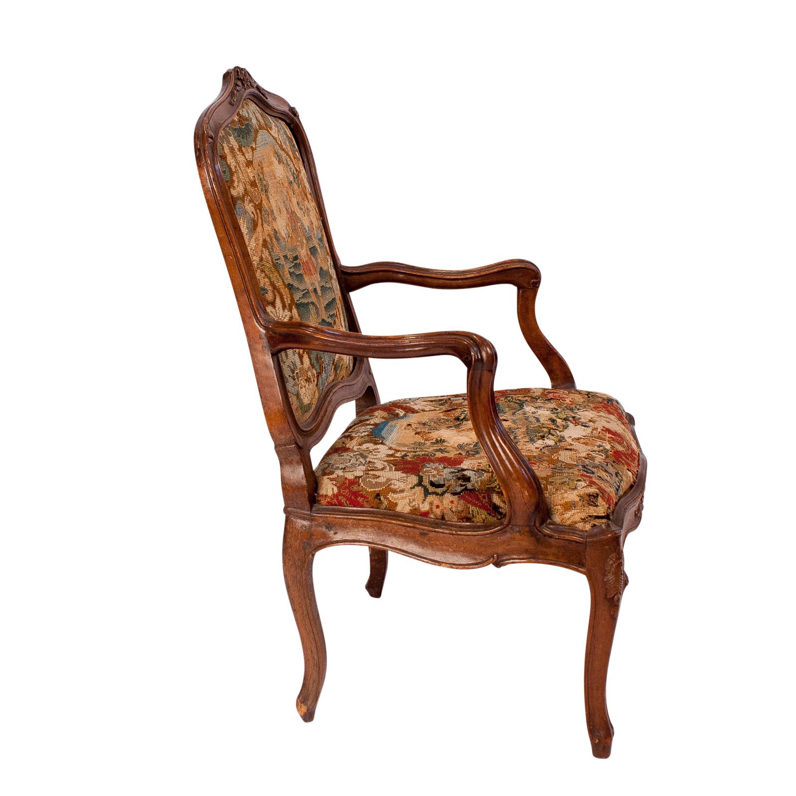 A late 18th century Italian baroque walnut armchair upholstered in tapestry. Ware to tapestry. Back in good shape seat distressed. Upholstery needs attention. These larger Italian armchairs are hard to find. This one has great old surface, wonderful