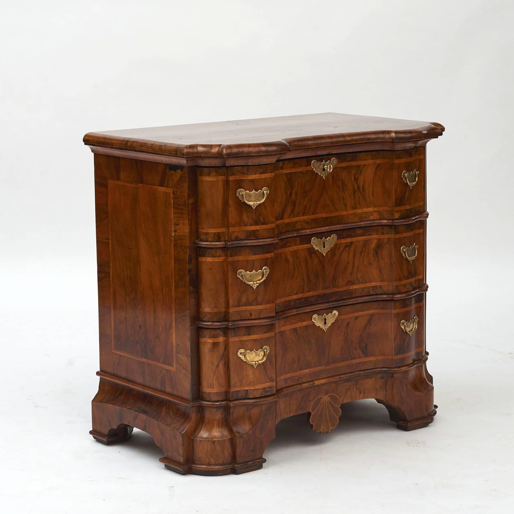 Rare Baroque chest of drawers with architectural characteristics.
Walnut veneer with light marquetry on front, top and sides.
Serpentine front with 3 drawers.
Original fittings.
From castle in Braunschweig, Germany approx. 1730

In great