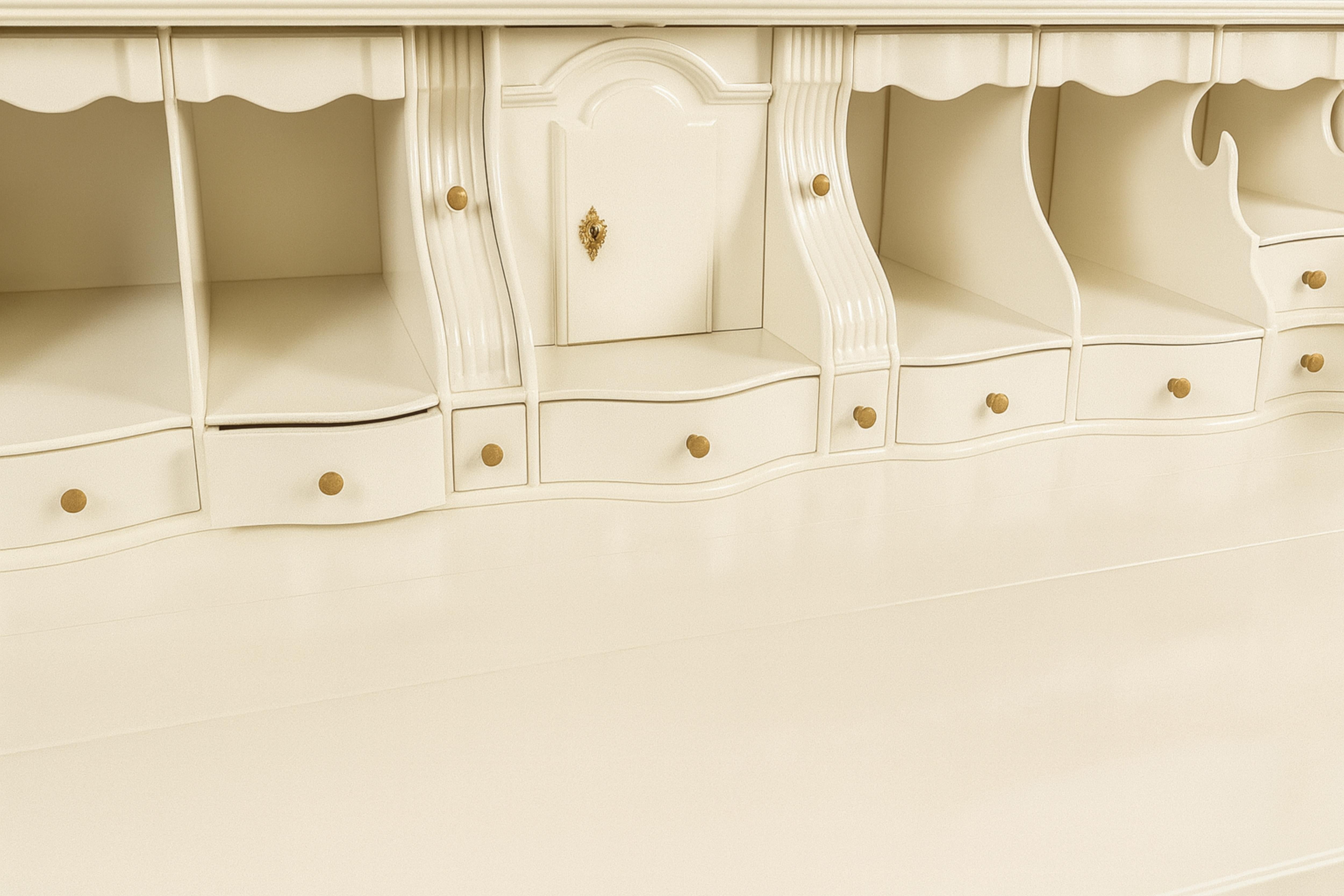 Mueble de nogal macizo lacado en blanco de principios del siglo XX. Caja con frente y laterales de líneas recortadas y abombadas, curvas asimétricas inusuales, compuesta por dos cajones superiores rematados con una camilla y tres cajones grandes. El