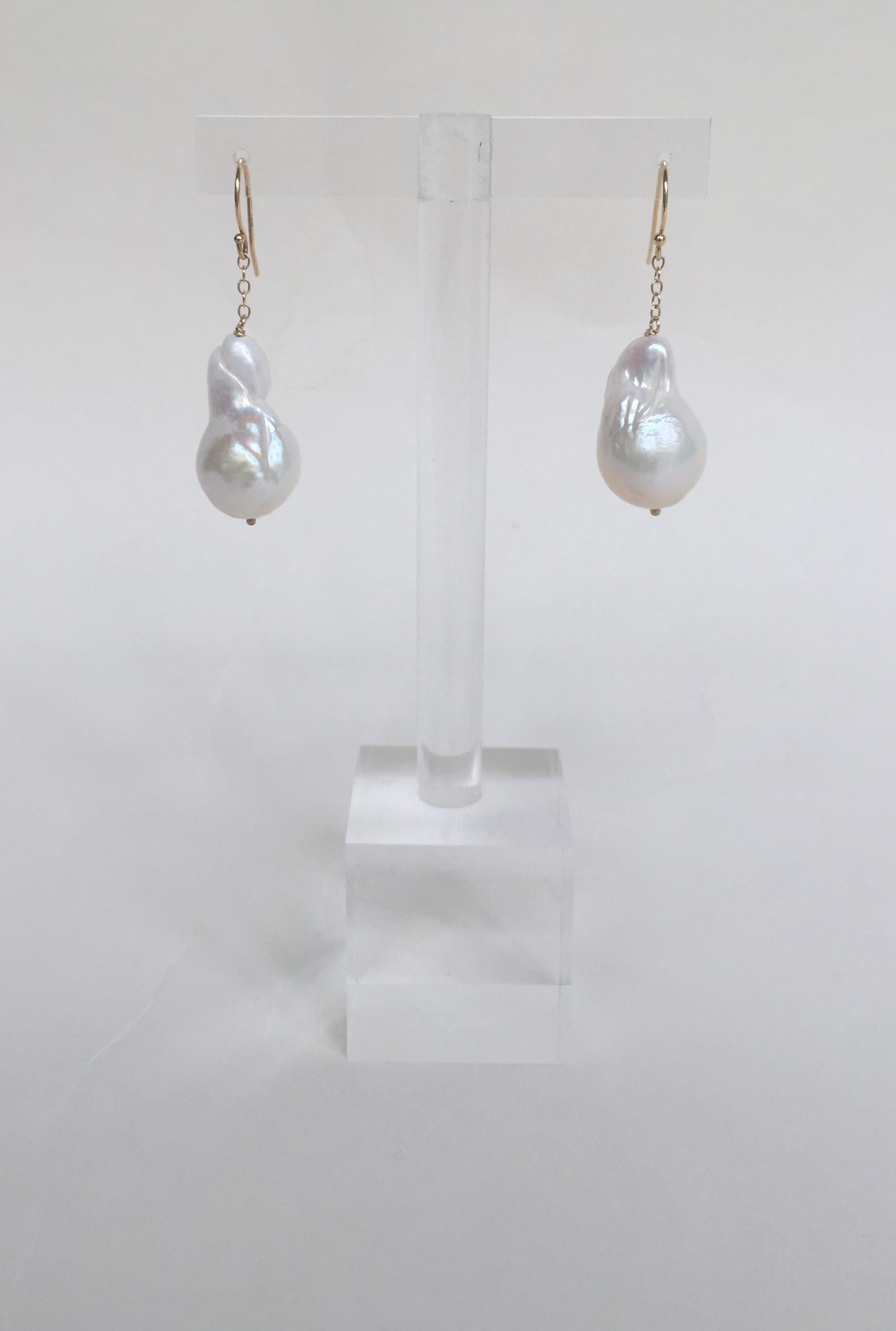 These baroque white pearl dangle earrings with 14k yellow gold chain and hook are stunning. A large baroque white pearl hangs from the 14 yellow gold, giving these dangle earrings drama as they sway with movement. The 14k yellow gold hooks complete