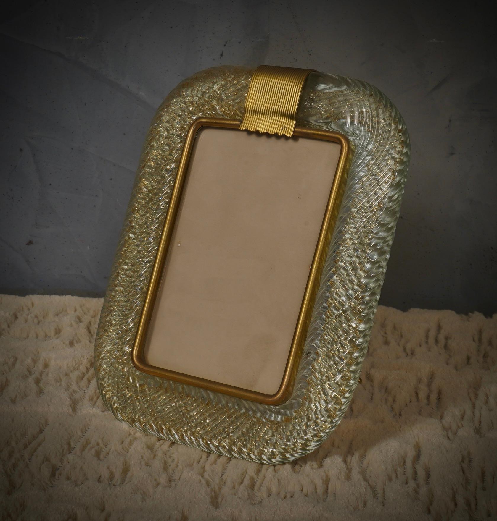 Magnifique cadre Murano de Barovier&Toso Murano, en laiton et verre transparent. Raffinement et classe, typiques du style Murano, ces pièces uniques resteront précieuses à jamais.

Cadre en laiton avec un large bord arrondi en verre de Murano bleu