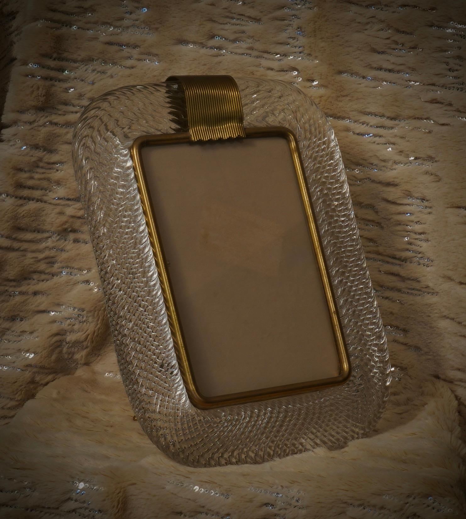 Splendid Murano frame by Barovier & Toso Murano, in brass and clear glass. Refinement and class, typical of Murano style, these one-of-a-kind pieces will remain precious forever.

Brass frame with a wide, round edge in clear Murano glass. The glass