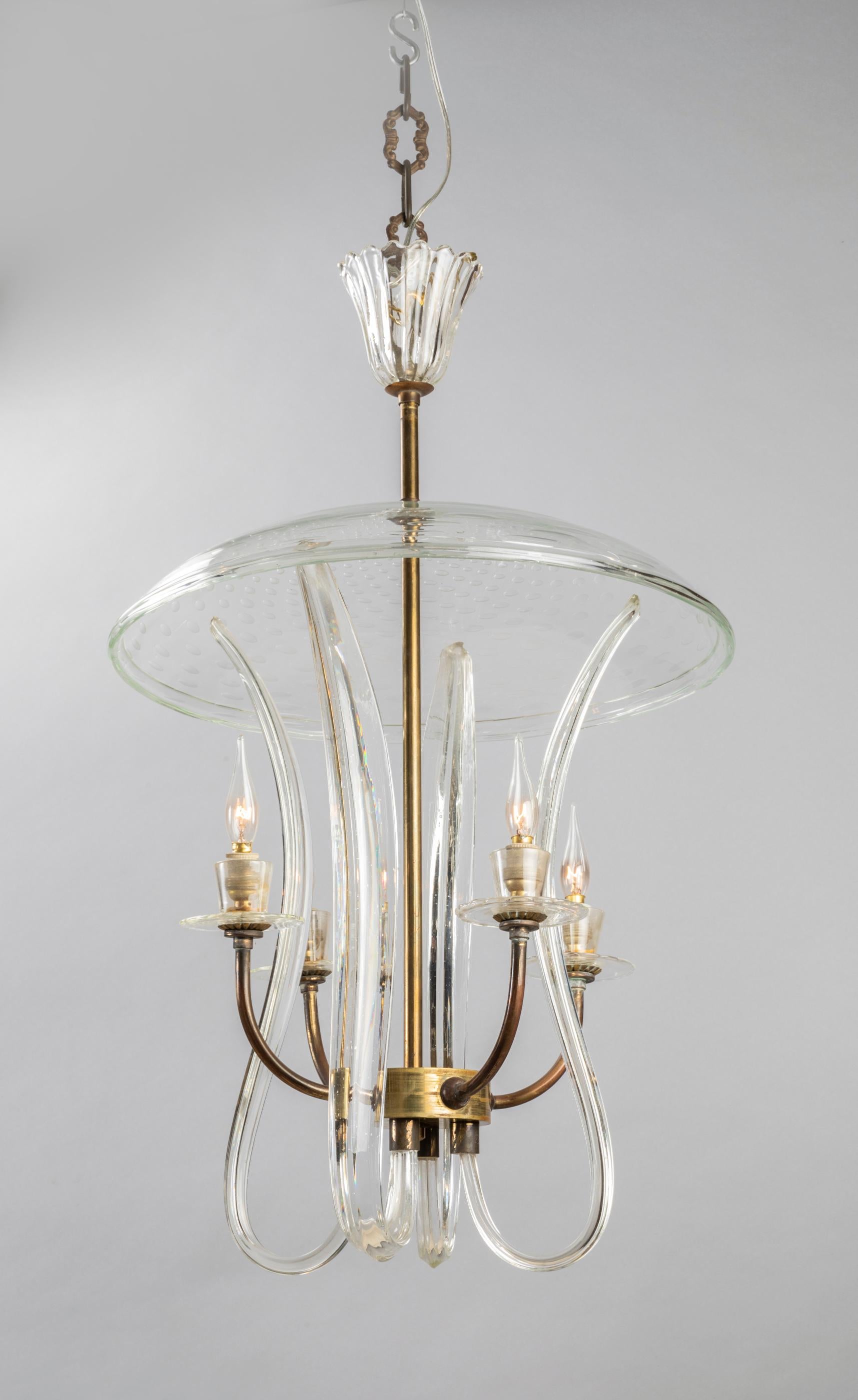 A delicate suspension lamp in a traditional Venetian spirit entirely of handmade glass.
This piece seems to float in the air and diffuse a soft light. It has been realised in 1940, authentical Murano blown glass.
