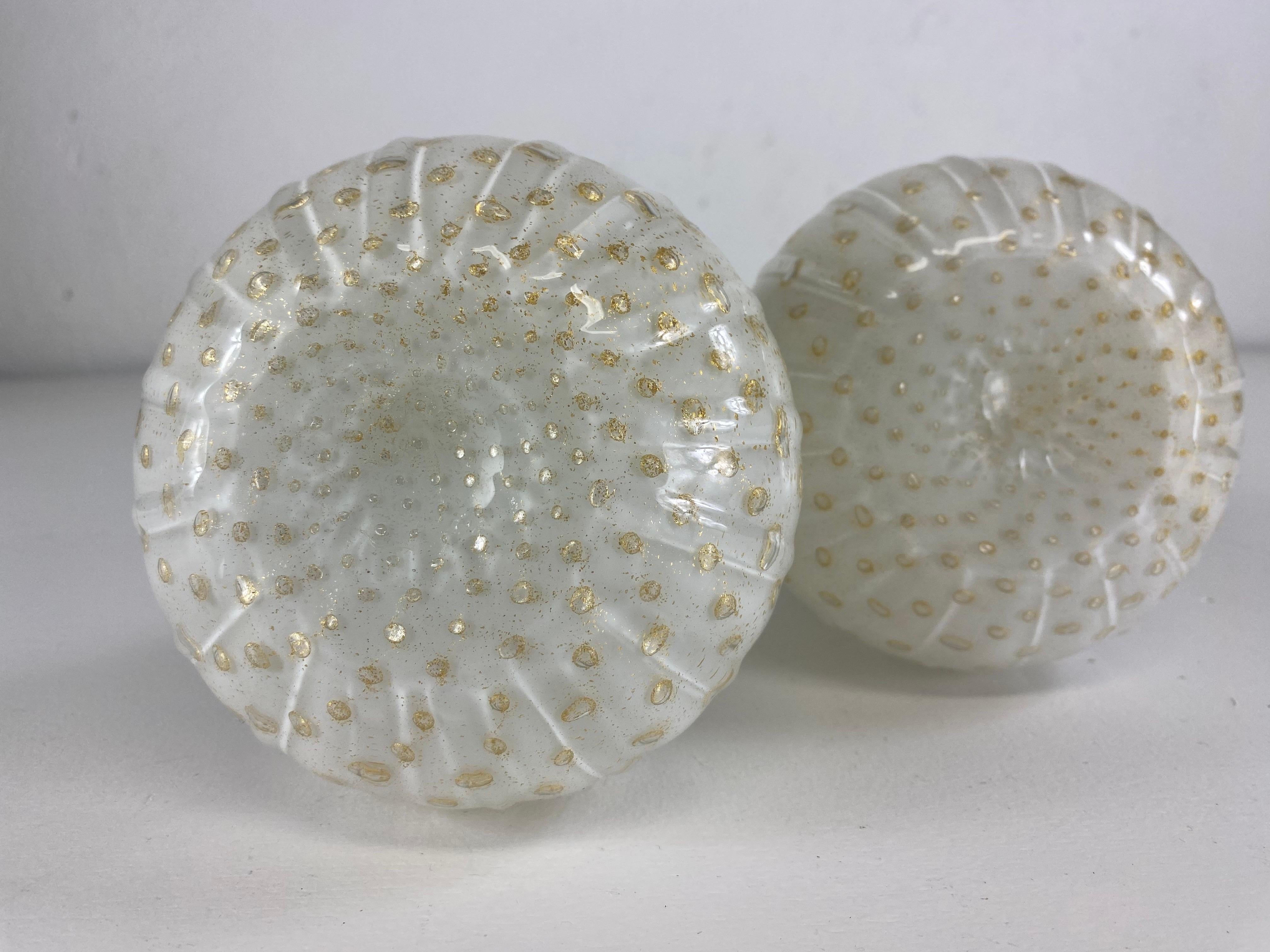 Si tratta di una coppia di vasi in vetro artistico di Murano della metà del secolo scorso. Questa coppia di vasi è stata soffiata con un effetto a bolle in stile polkadot. I vasi presentano una decorazione a coste con una flessione in oro a 22