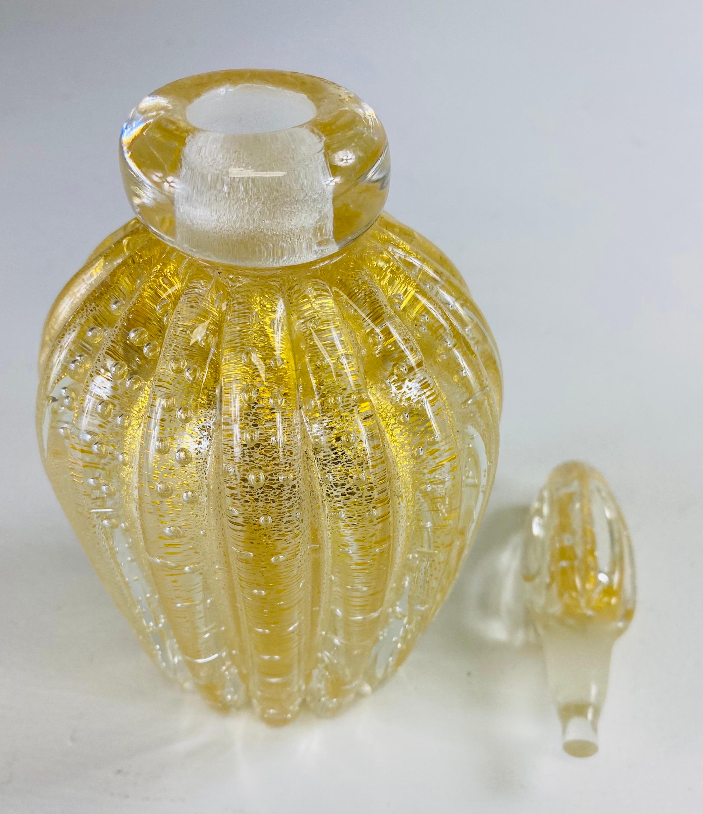 Il s'agit d'un flacon de parfum en verre de Murano soufflé à la main avec bouchon. Ce flacon de parfum vintage du milieu du siècle est orné d'un filet d'or 22 carats et est accompagné de son bouchon d'origine. L'étiquette d'origine, illisible, se