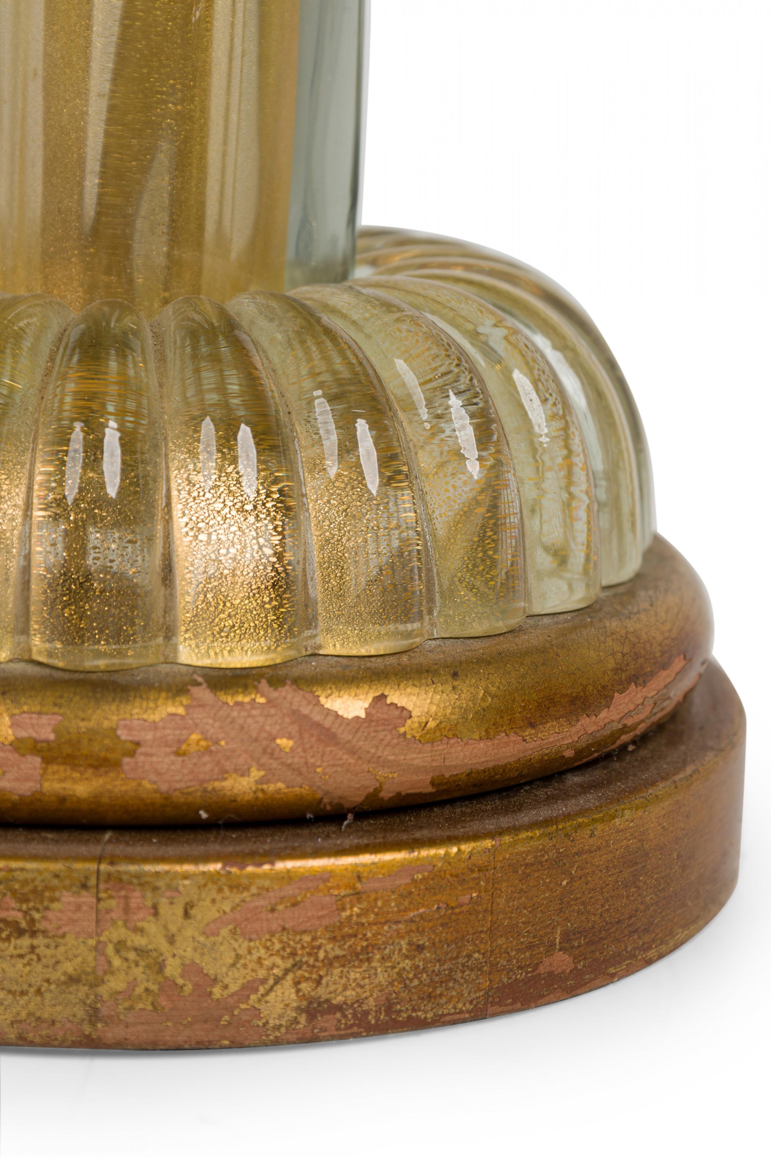 Lampe de table en verre italienne du milieu du siècle en forme de colonne torsadée avec une tige en laiton prolongée surmontée d'un fleuron en forme de coupe renversée, deux prises de courant fonctionnelles avec des tirettes perlées, et un pied en