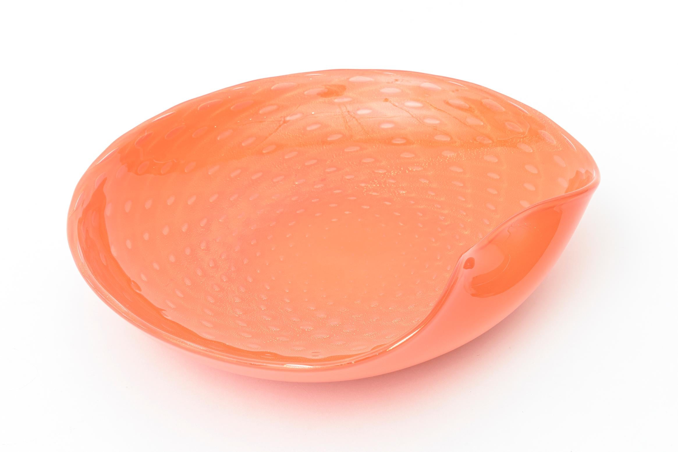 This lovely Italian Murano hand blown glass bowl with gold aventurine is by Barovier e Toso. It is vintage from the 1960s. This orange bowl is a beautiful luscious shade with abundance of almond shaped gold aventurine in the glass. Perfect for