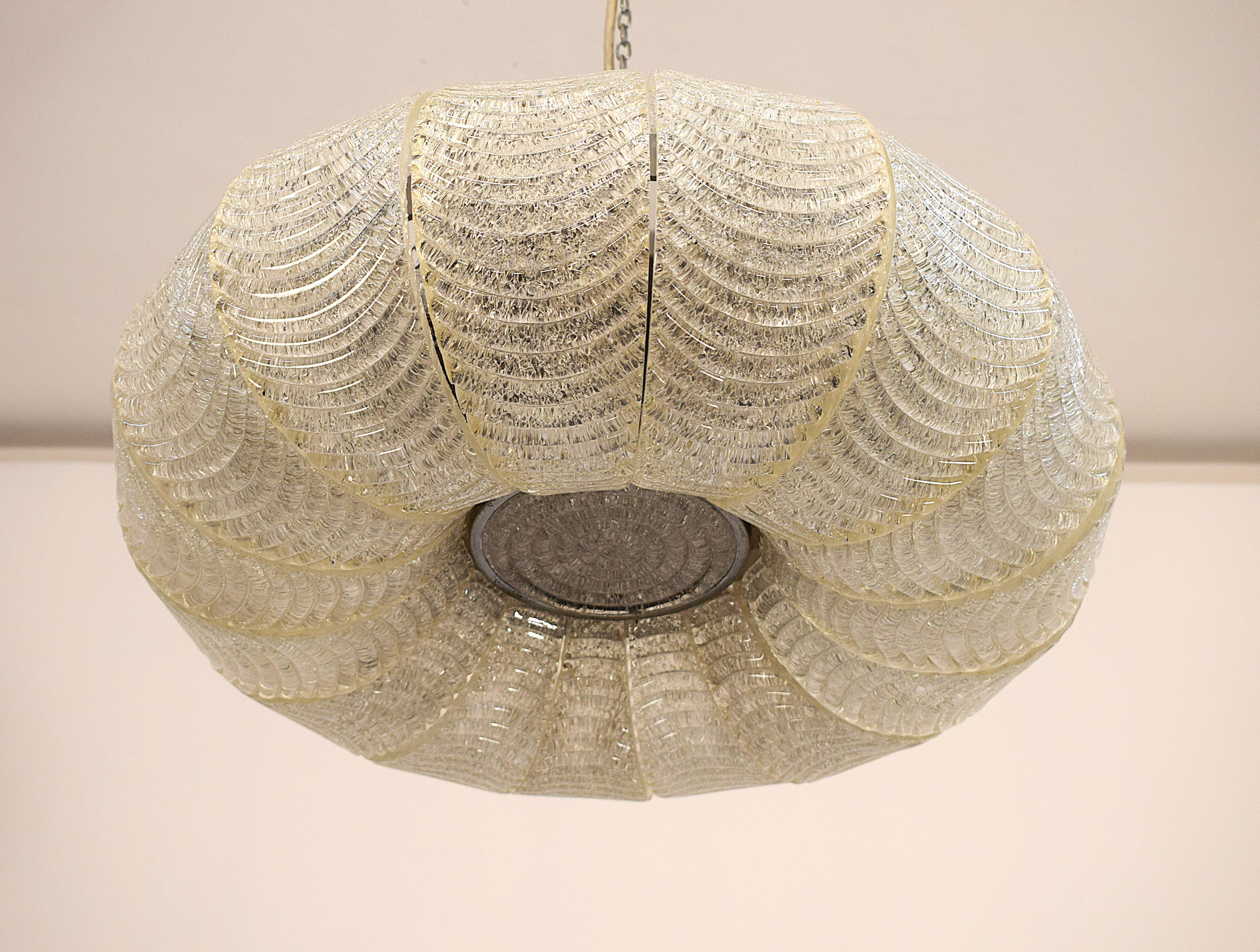 Elegante lampadario attribuito a Barovier, realizzato negli anni '70 in vetro e metallo di alta qualità. Questo raffinato pezzo vintage presenta un design ricercato a forma di conchiglia, con vetro lavorato a rilievo che diffonde una luce calda e