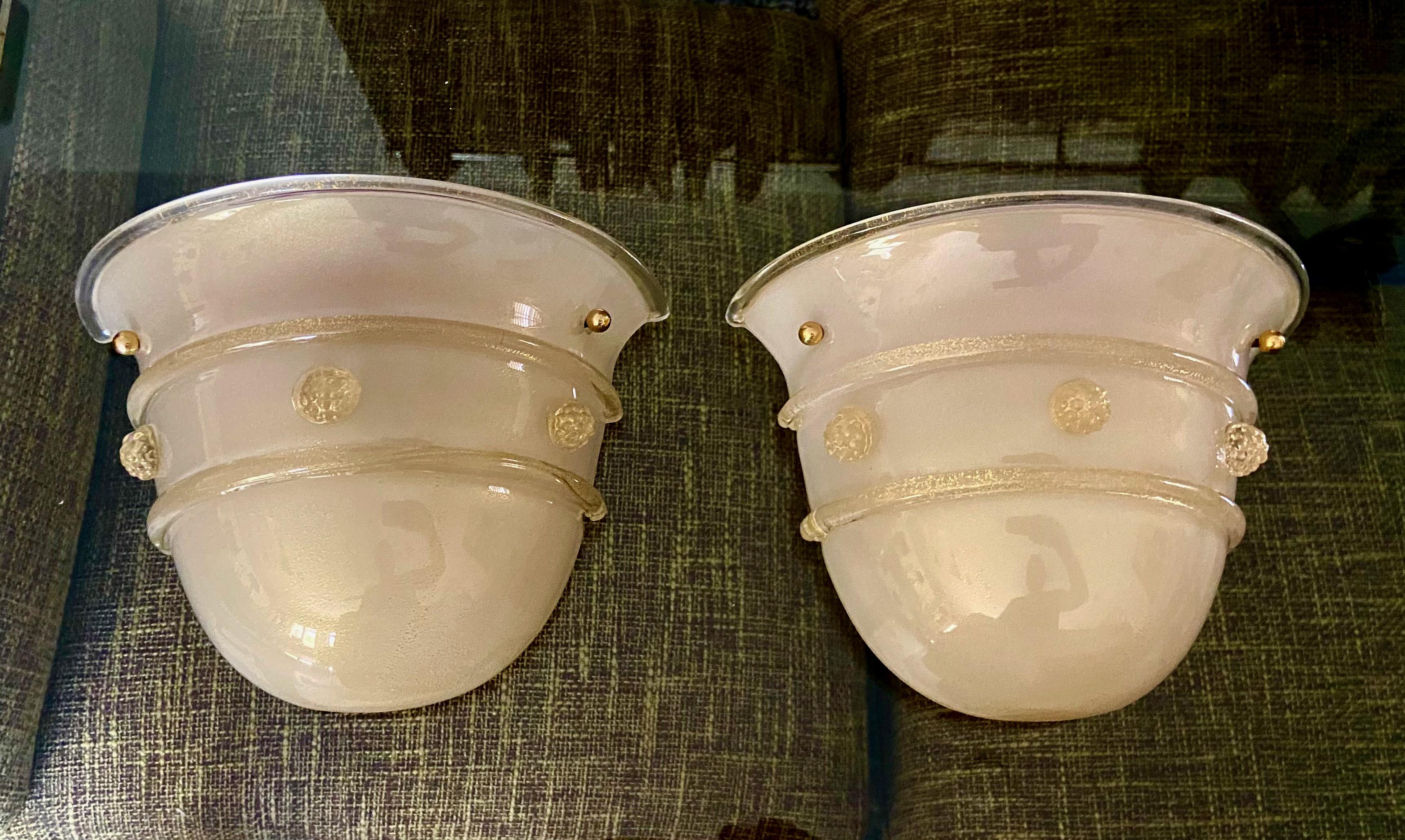 Pair of wall sconces by Barovier & Toso. Opaque glass covered by clear glass with fine scattering of gold flecks. Glass details and florets are in clear and gold. Newly wired. Each fixture uses one candelabra base bulb.