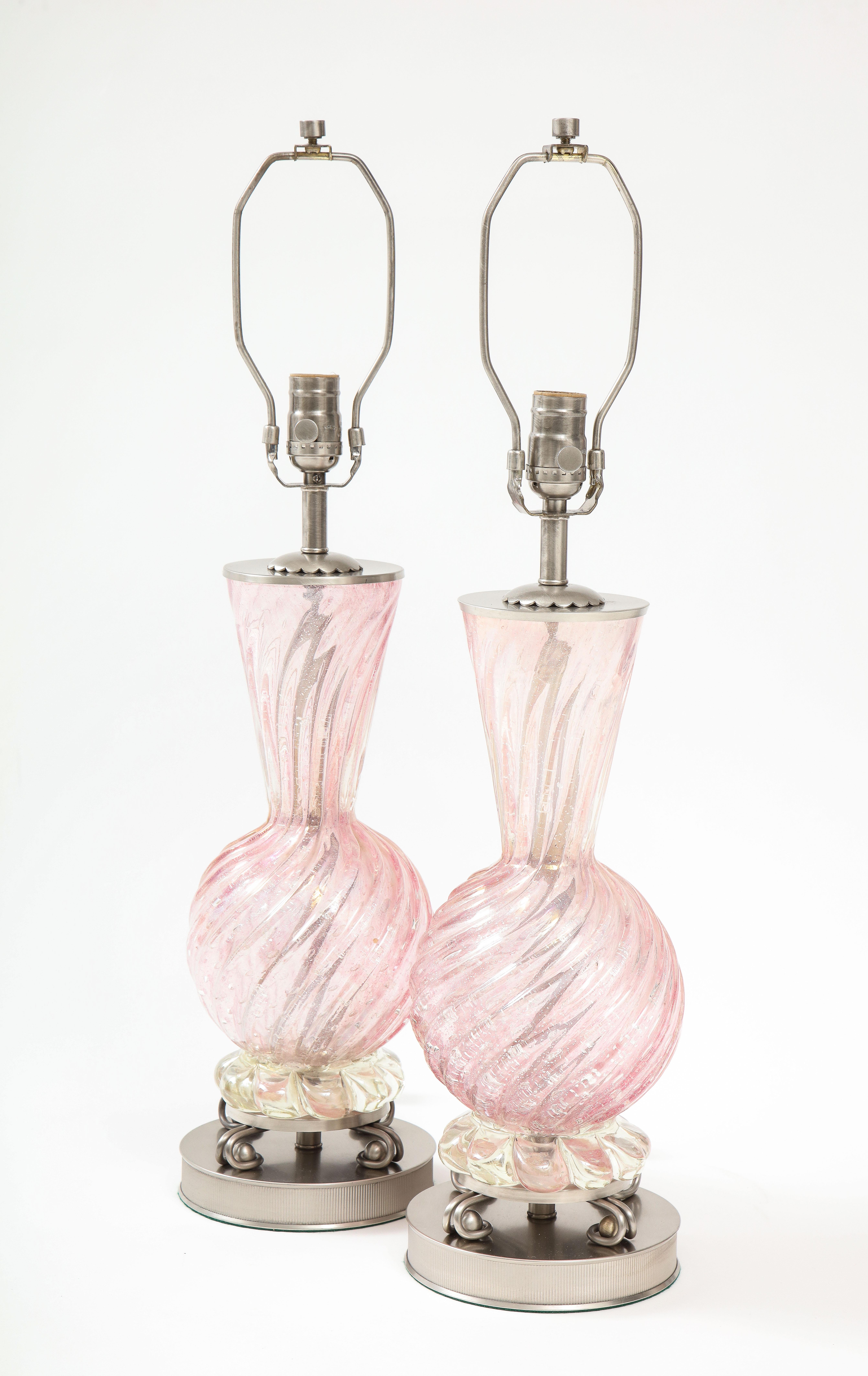 Pair of Mid Century/Art Deco Murano glass lamps in a pale pink featuring a swirl blown pattern and silver dust inclusions. Glass lamps sit on polished nickel bases. Rewired for use in USA, 100W max bulbs.
