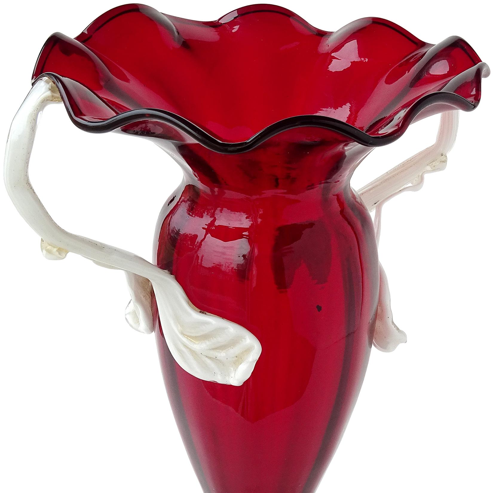 Magnifique et rare vase à fleurs en verre d'art italien antique de Murano, soufflé à la main, d'un rouge rubis intense, avec des décorations de feuilles blanches sur l'anse, saupoudrées d'or. Documenté et étiqueté comme Artistica Soffiera Vetreria -