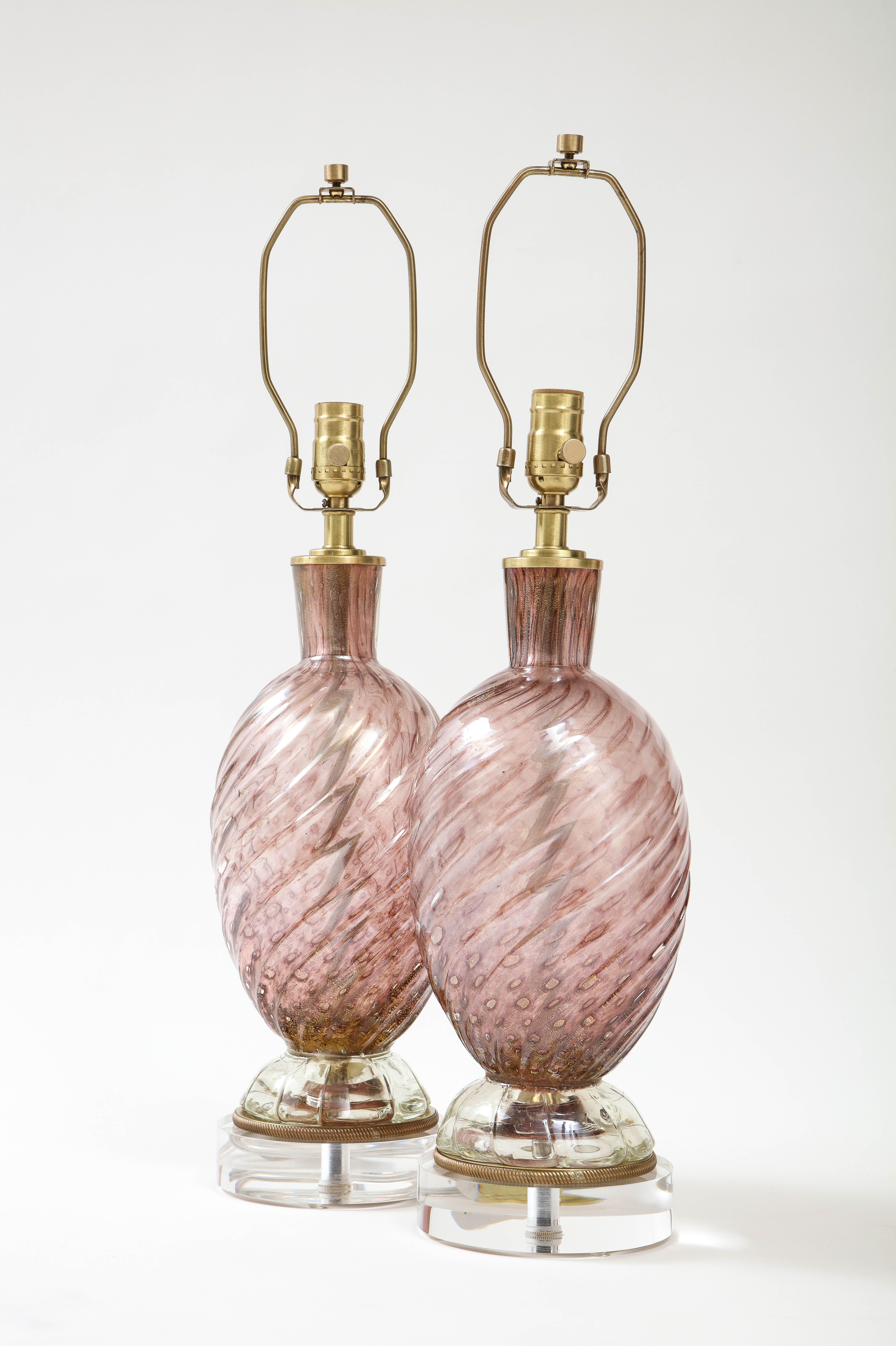Pair of Smoked Amethyst Murano Glass lamps featuring a swirled design and gold dust inclusions throughout. Lamps sit on satin brass and Lucite bases. Rewired for use in the USA, 100W max bulbs.