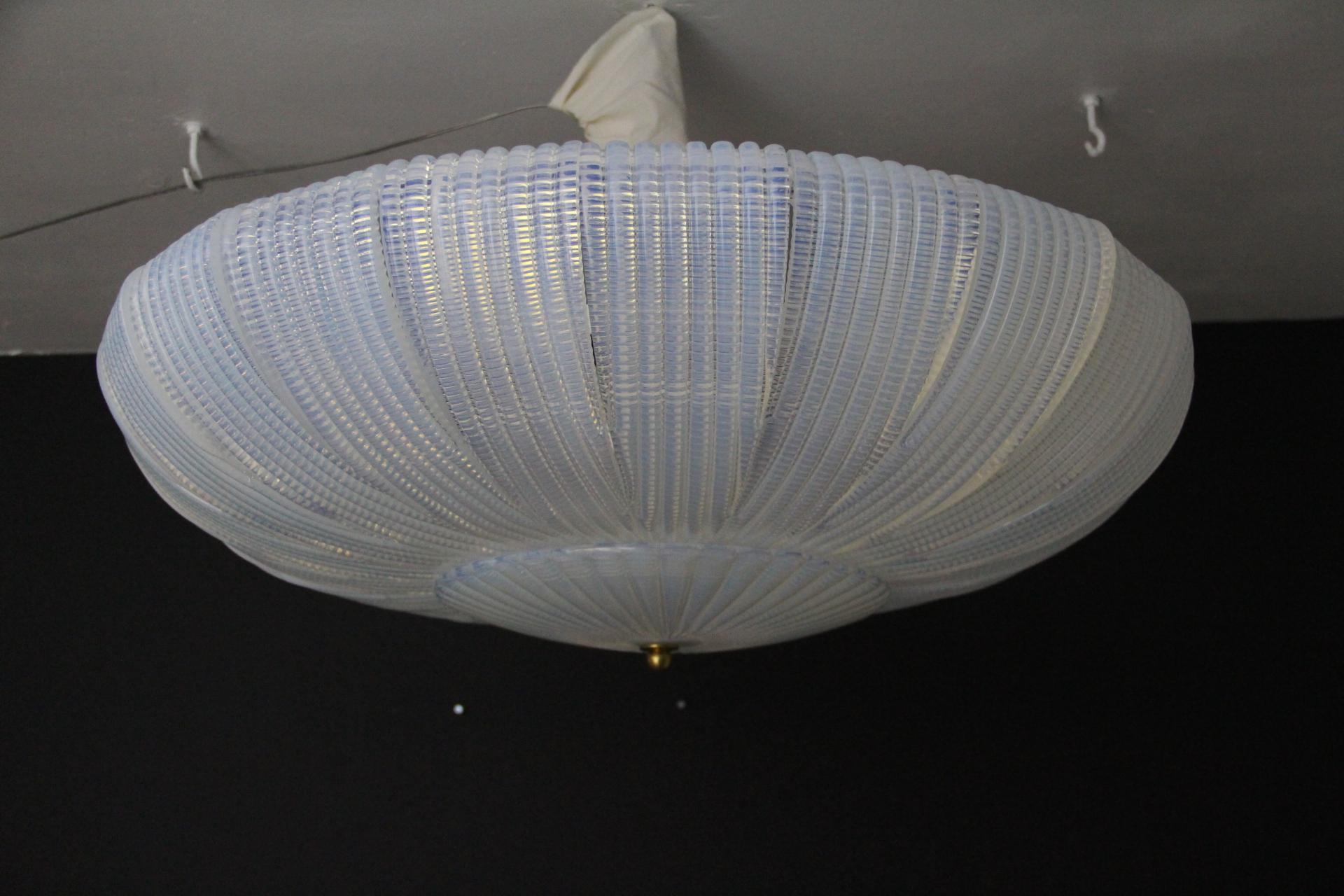 Questo splendido lampadario da incasso di metà secolo o art déco è caratterizzato da un vetro iridescente soffiato a mano. È composto da 22 pannelli in vetro soffiato a mano di Murano che ricordano la curva di una foglia, con le estremità sottili