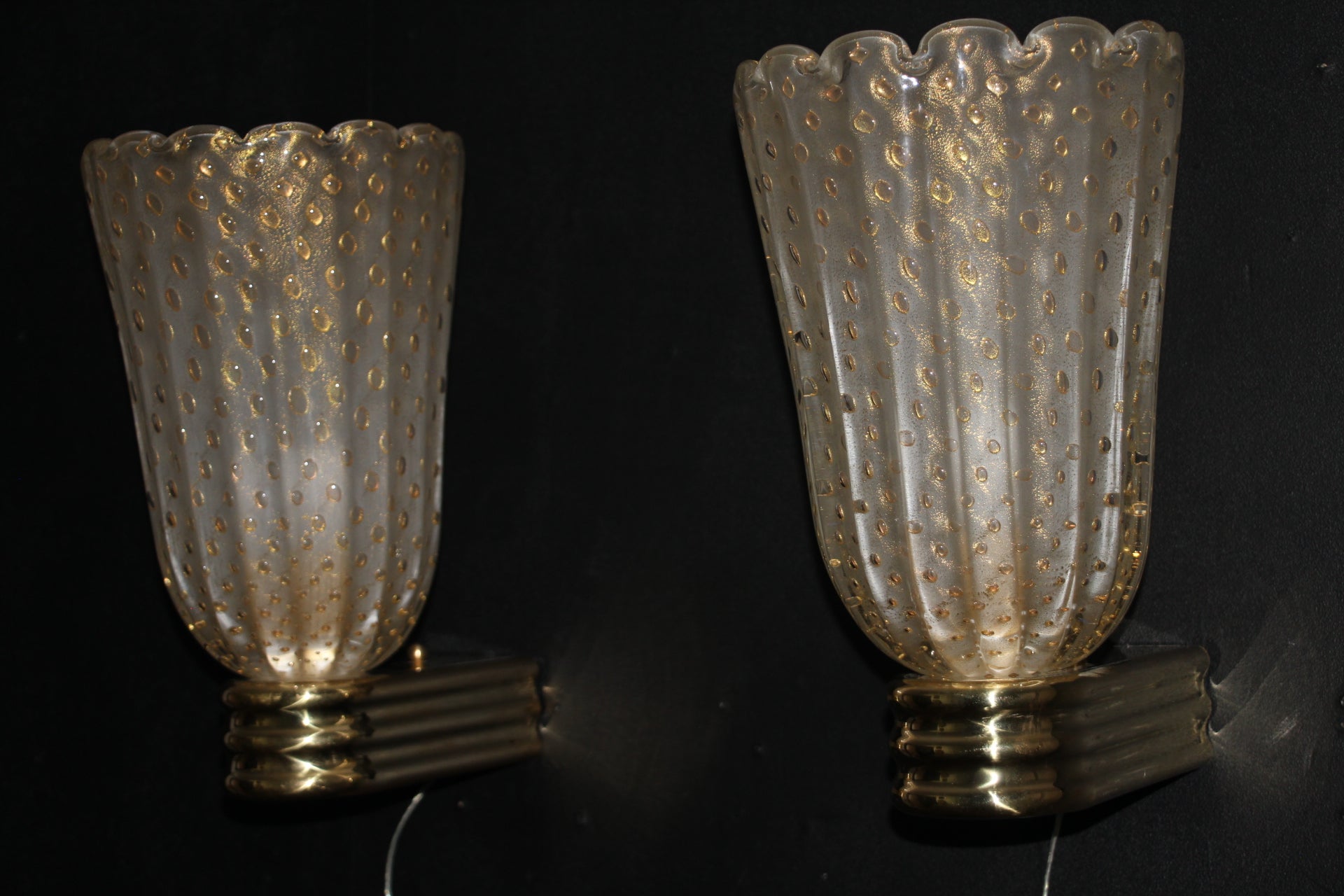 Cette fabuleuse paire d'appliques vénitiennes de style moderne ou Art Déco, a été entièrement réalisée à la main. Le tout est décoré avec la technique du Pulegoso. Cela signifie qu'il présente de grosses bulles d'air à l'intérieur de son verre